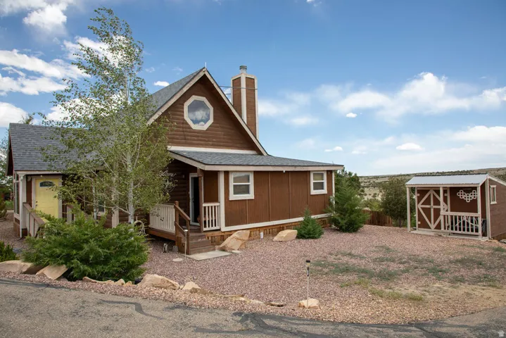 Brown siding exterior with white trim, a gabled roofline, and a prominent chimney