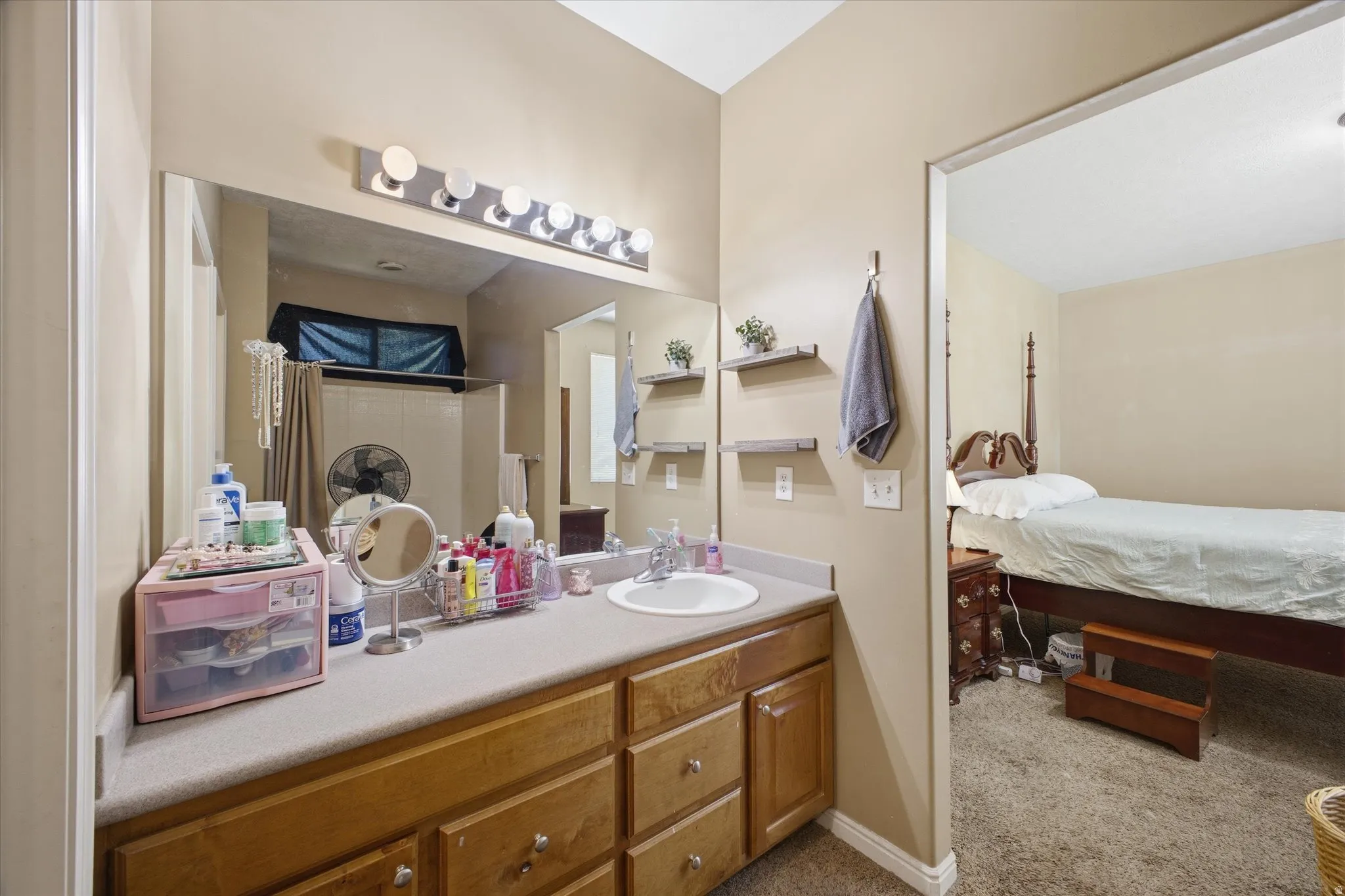 Bathroom vanity with a light-toned countertop and wood-finish cabinetry