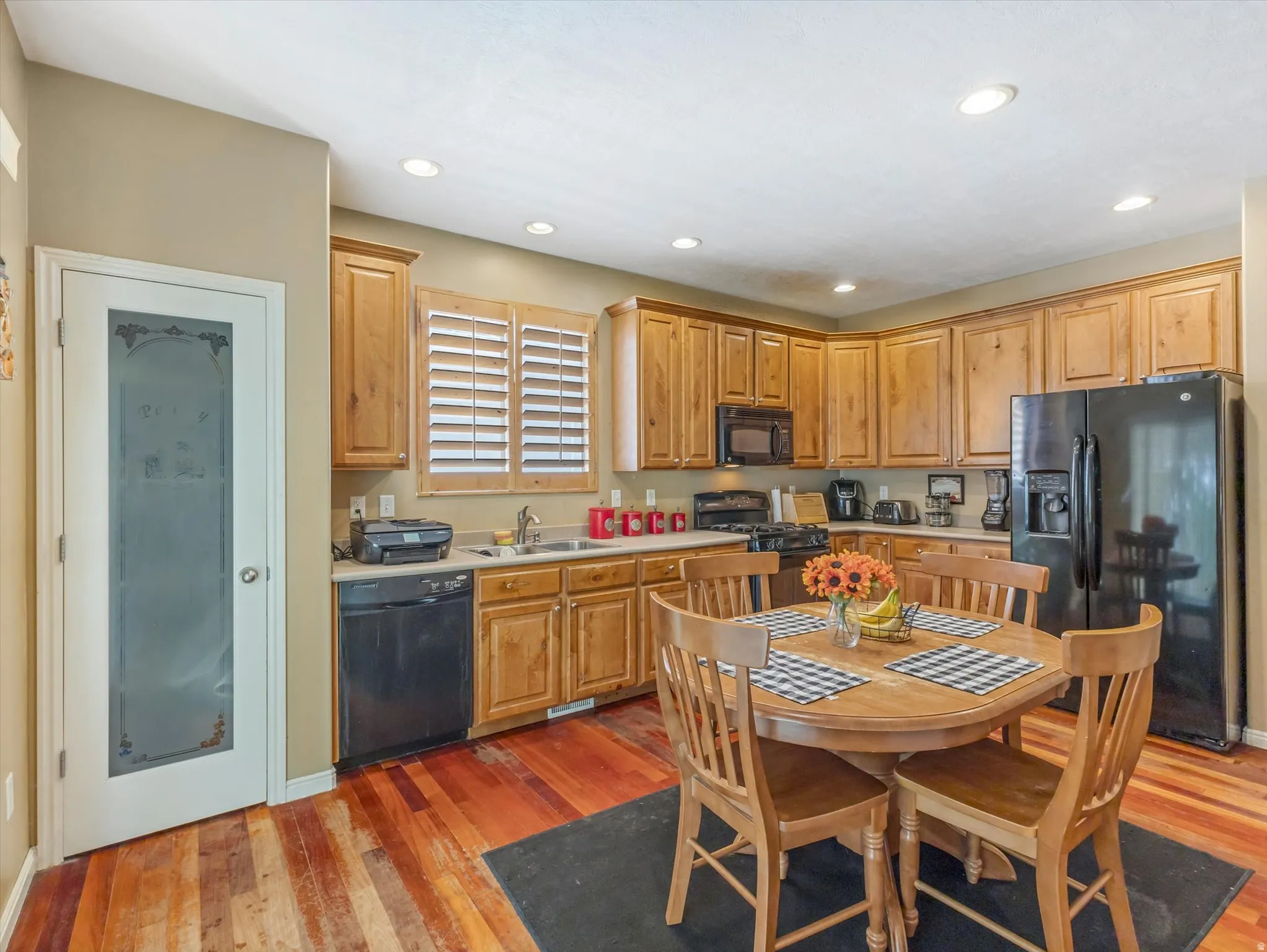 Full kitchen featuring wood-finish cabinetry, black appliances, recessed lighting, and wood-finish flooring