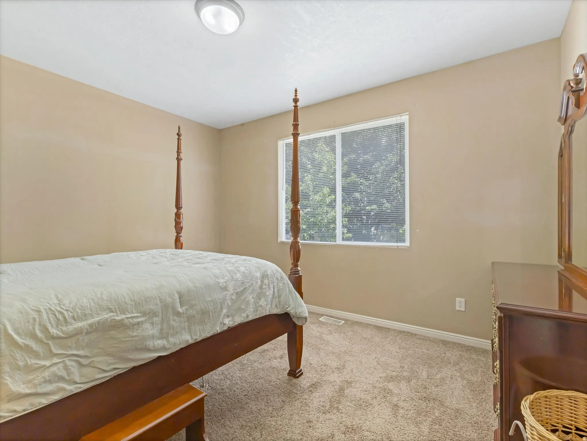 Bedroom featuring neutral wall paint, carpet flooring, a window with blinds, and an overhead flush-mount light fixture