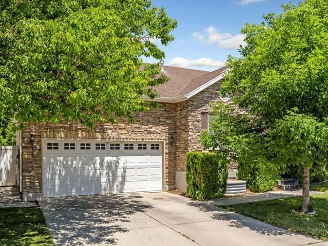 Stone veneer exterior with a brown shingle roof