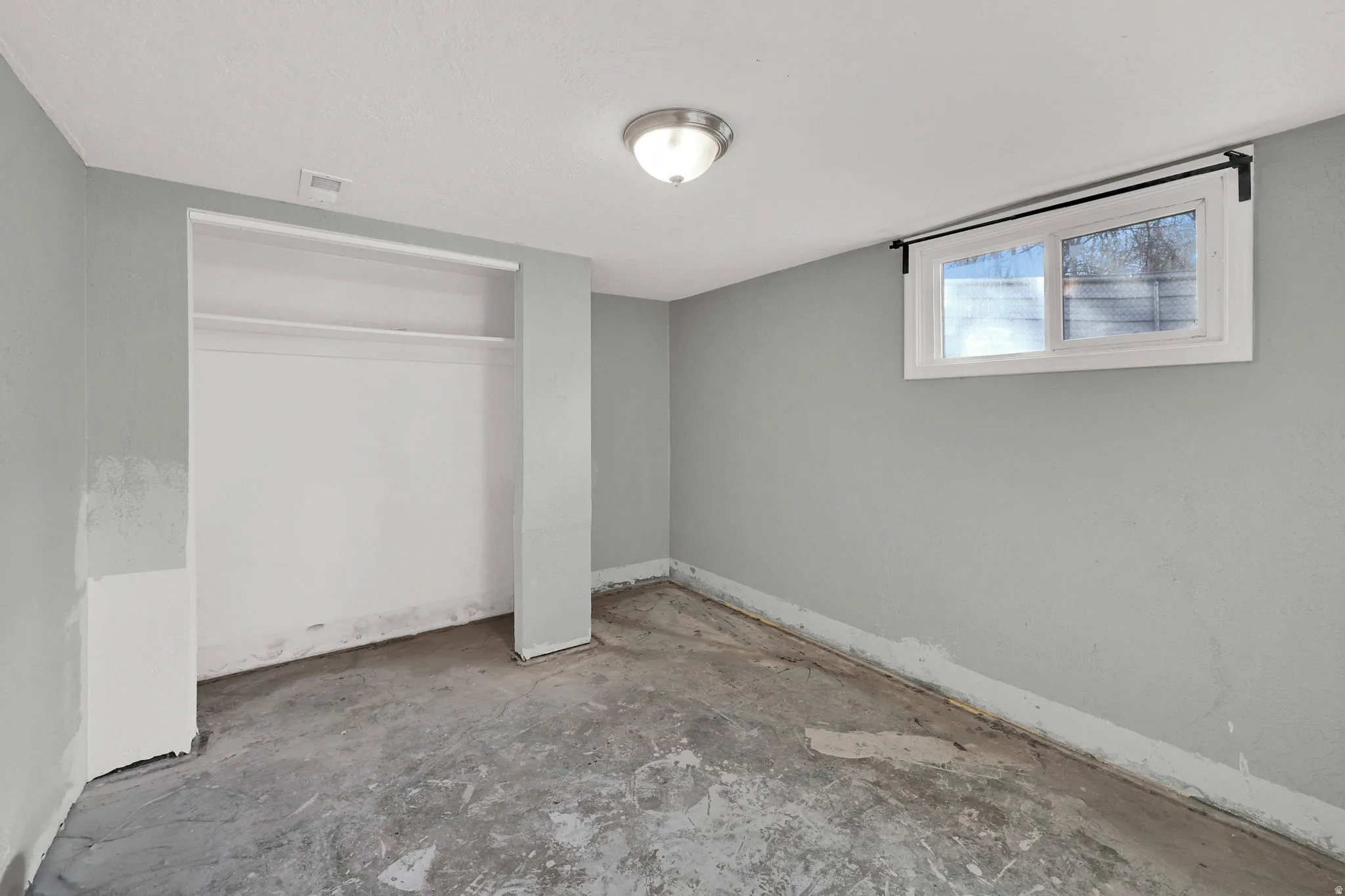 Room featuring light gray painted walls and a concrete floor