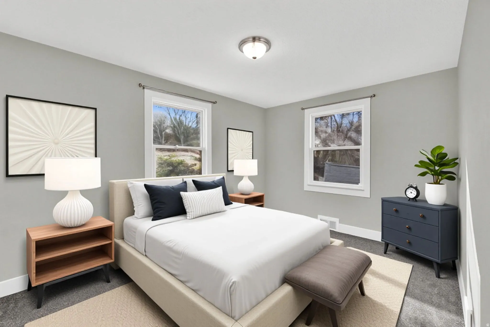 Room featuring two large windows with white trim, light gray walls, a flush-mount ceiling light fixture, and dark gray carpeting
