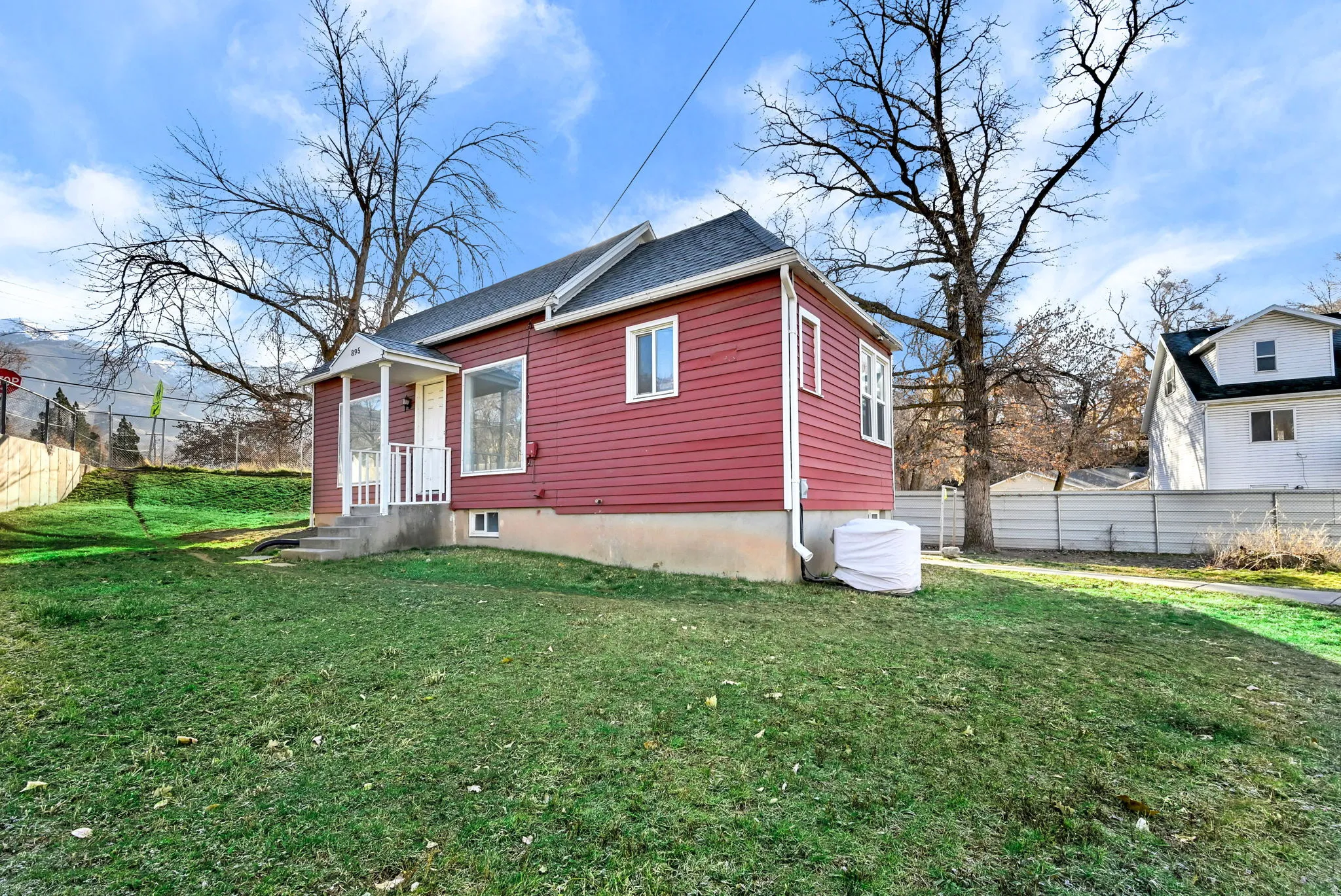 Red siding exterior with white trim windows and a covered entry