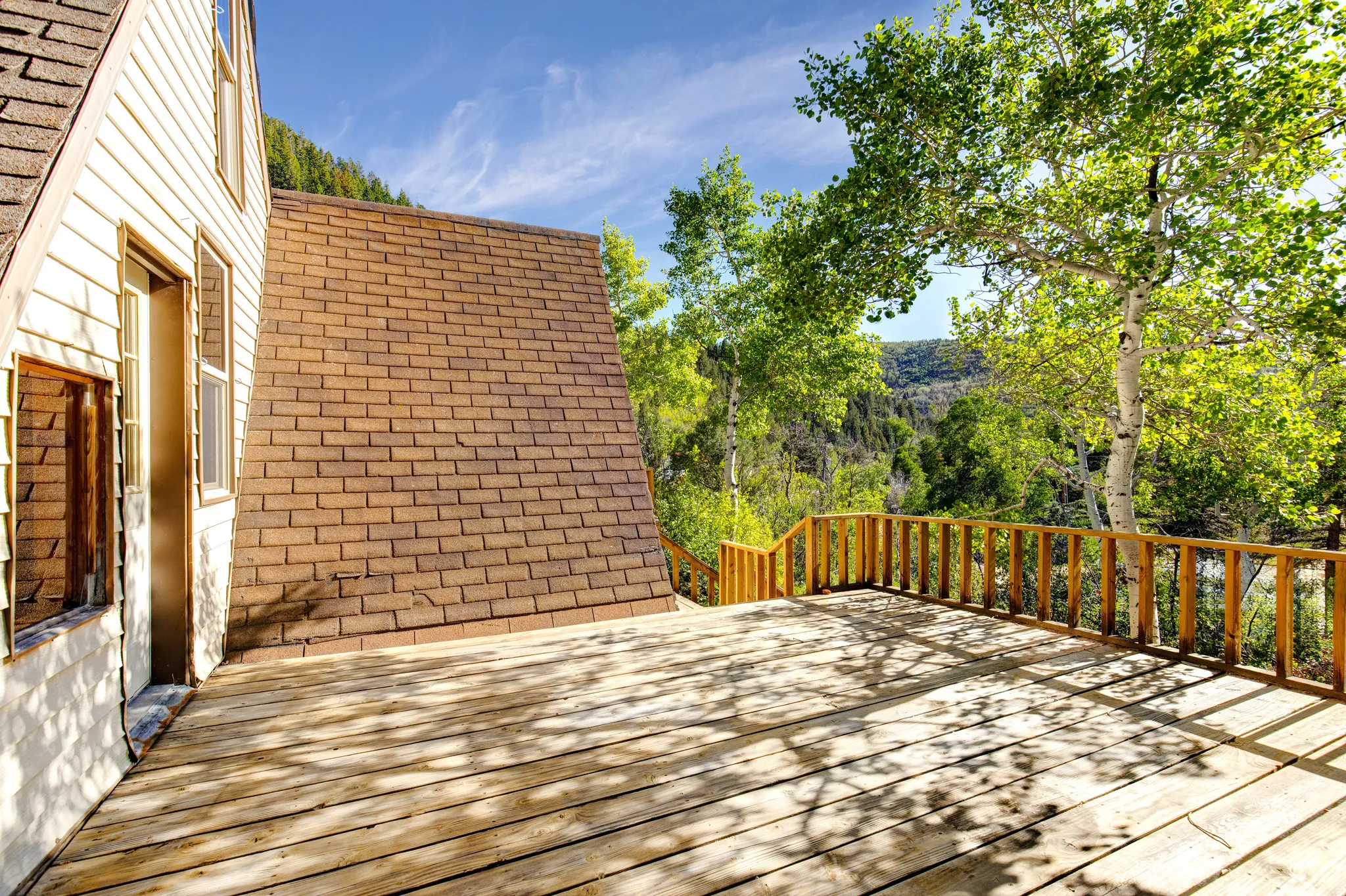 Expansive outdoor deck with natural wood planking and a matching wood railing