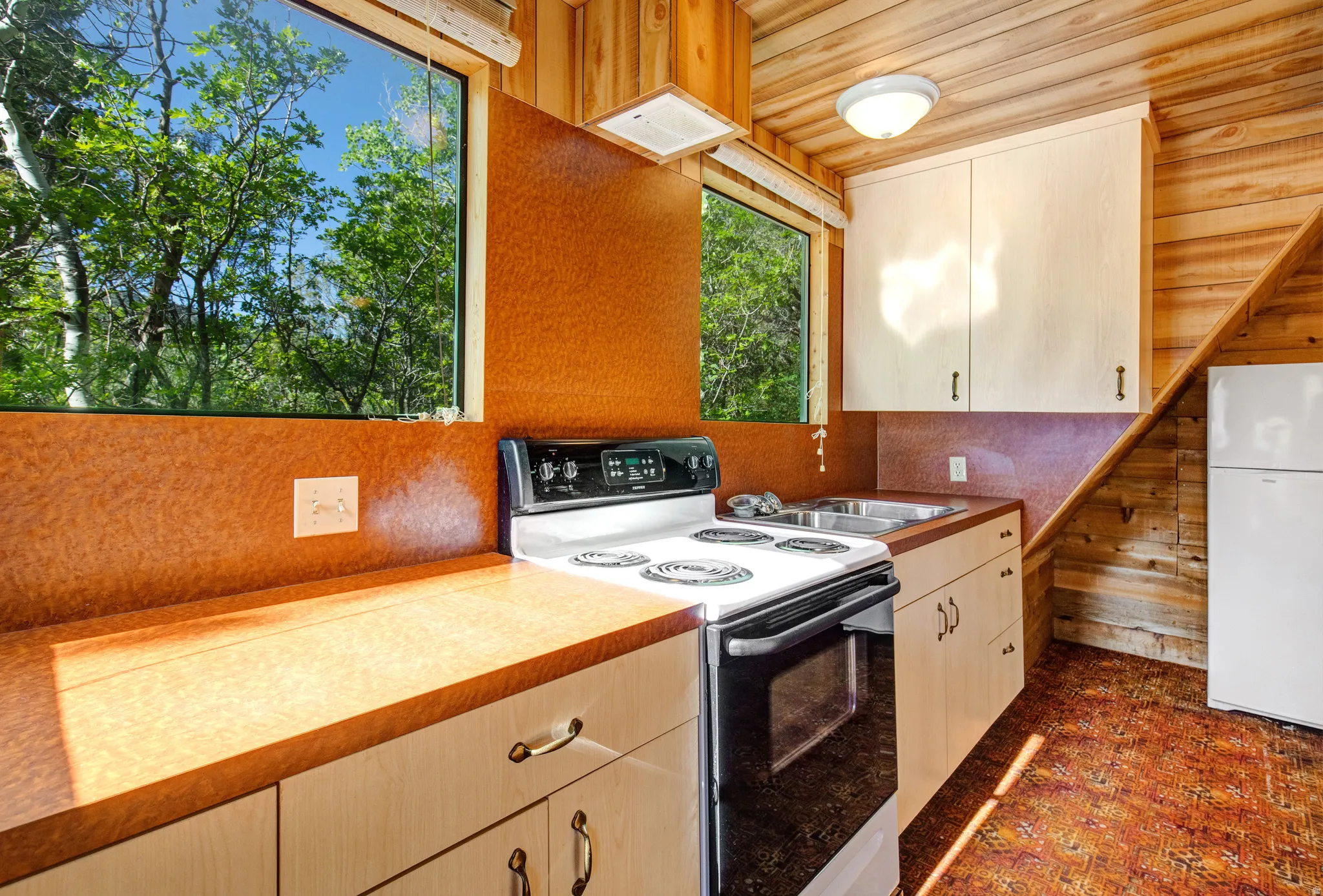 Kitchen featuring a white electric range, double basin sink, and wood-finish countertops