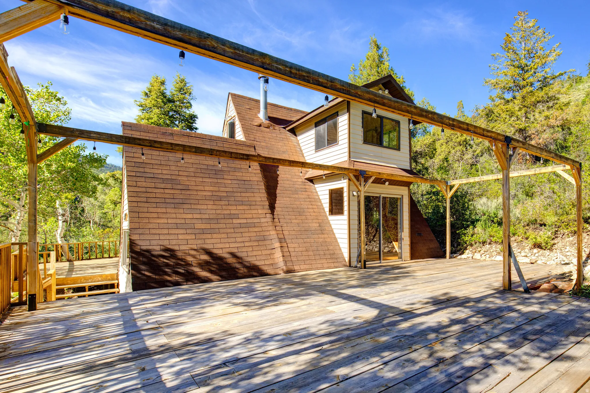 Expansive exterior wood-finish deck with an integrated pergola structure