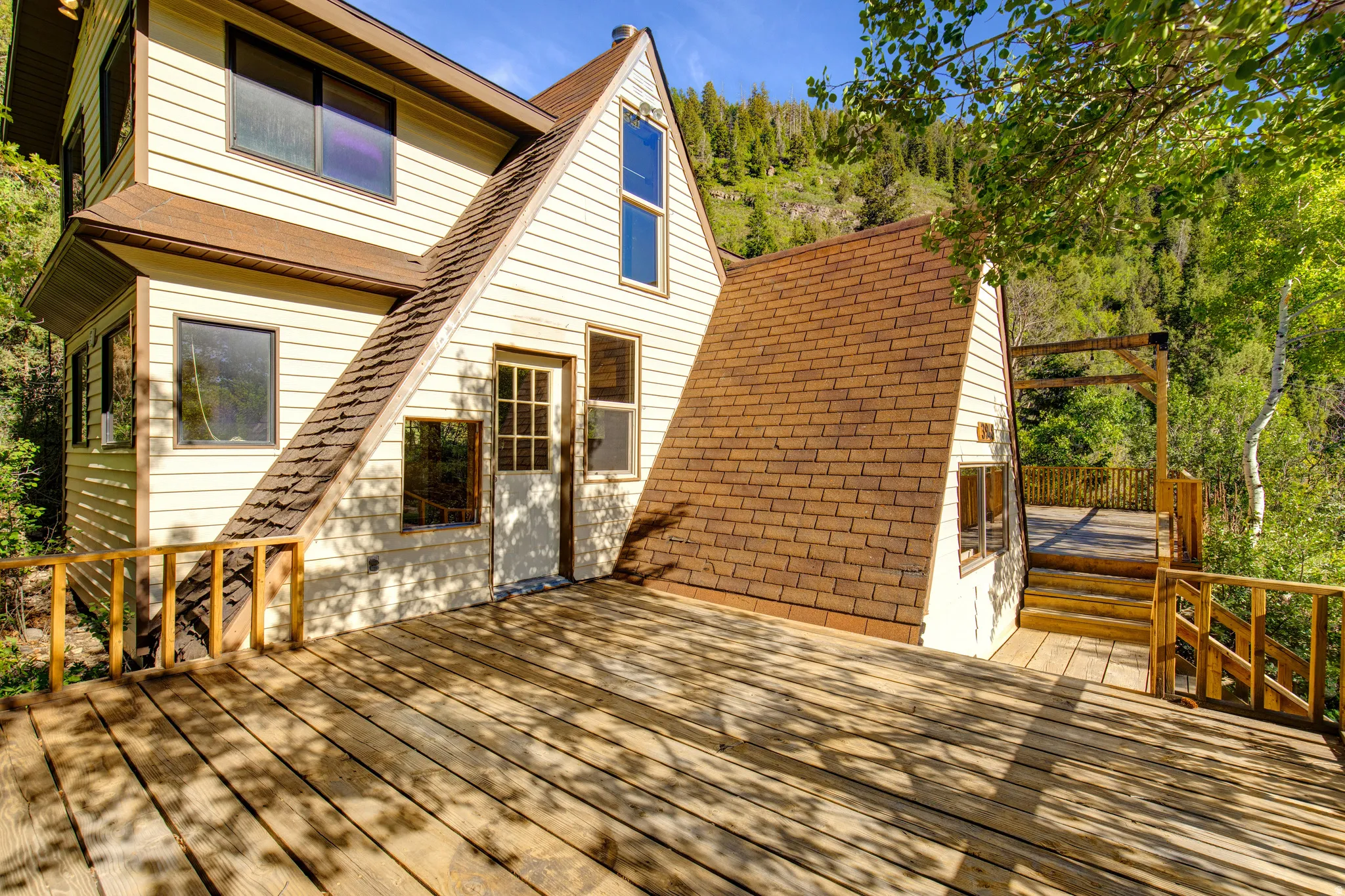 Expansive wood deck with natural wood railings, providing outdoor living space