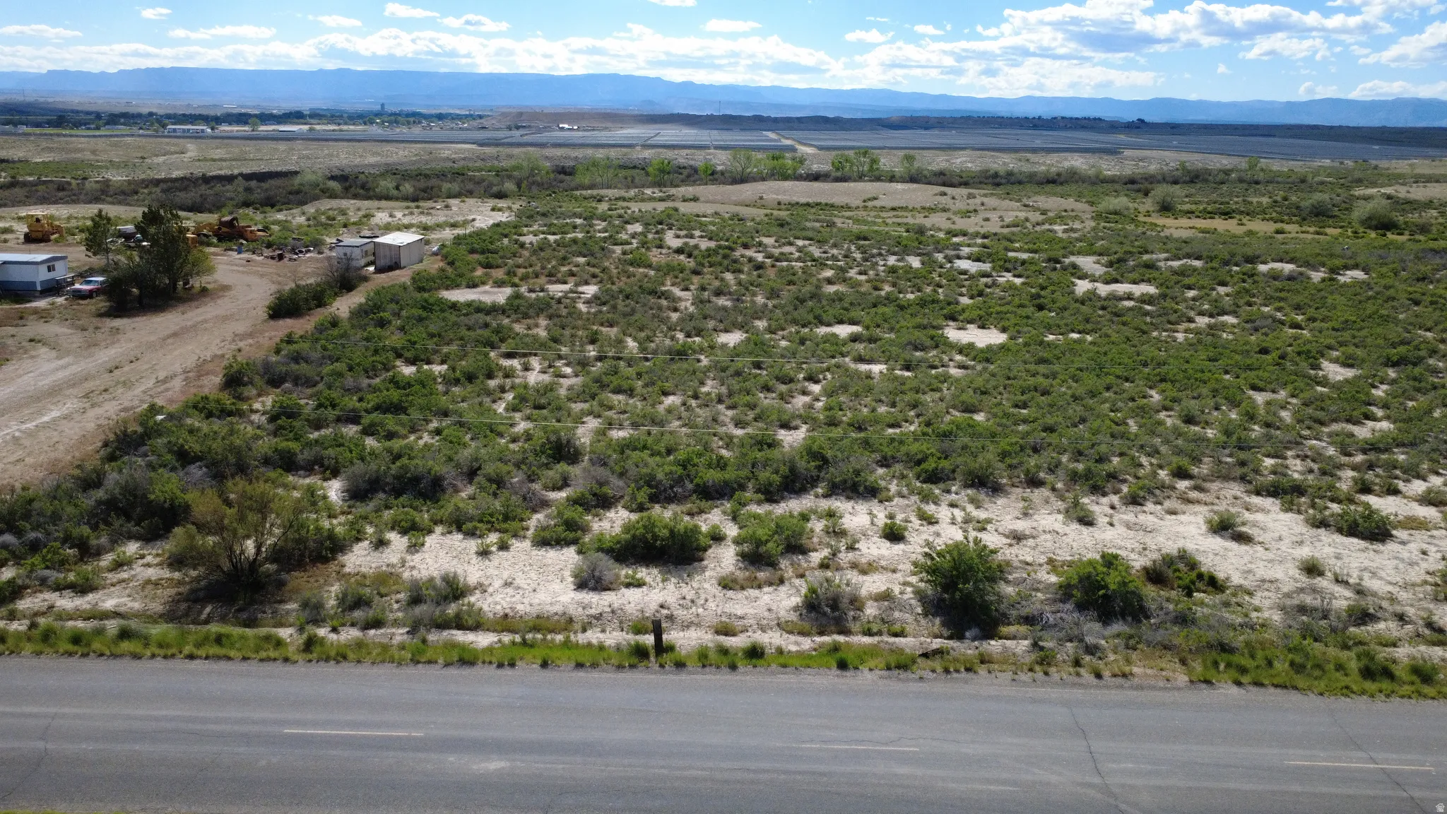 Expansive land parcel featuring natural shrubbery and a distant mountainous backdrop