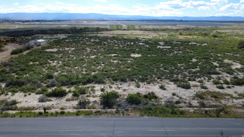 Expansive undeveloped land featuring natural vegetation and distant mountain ranges