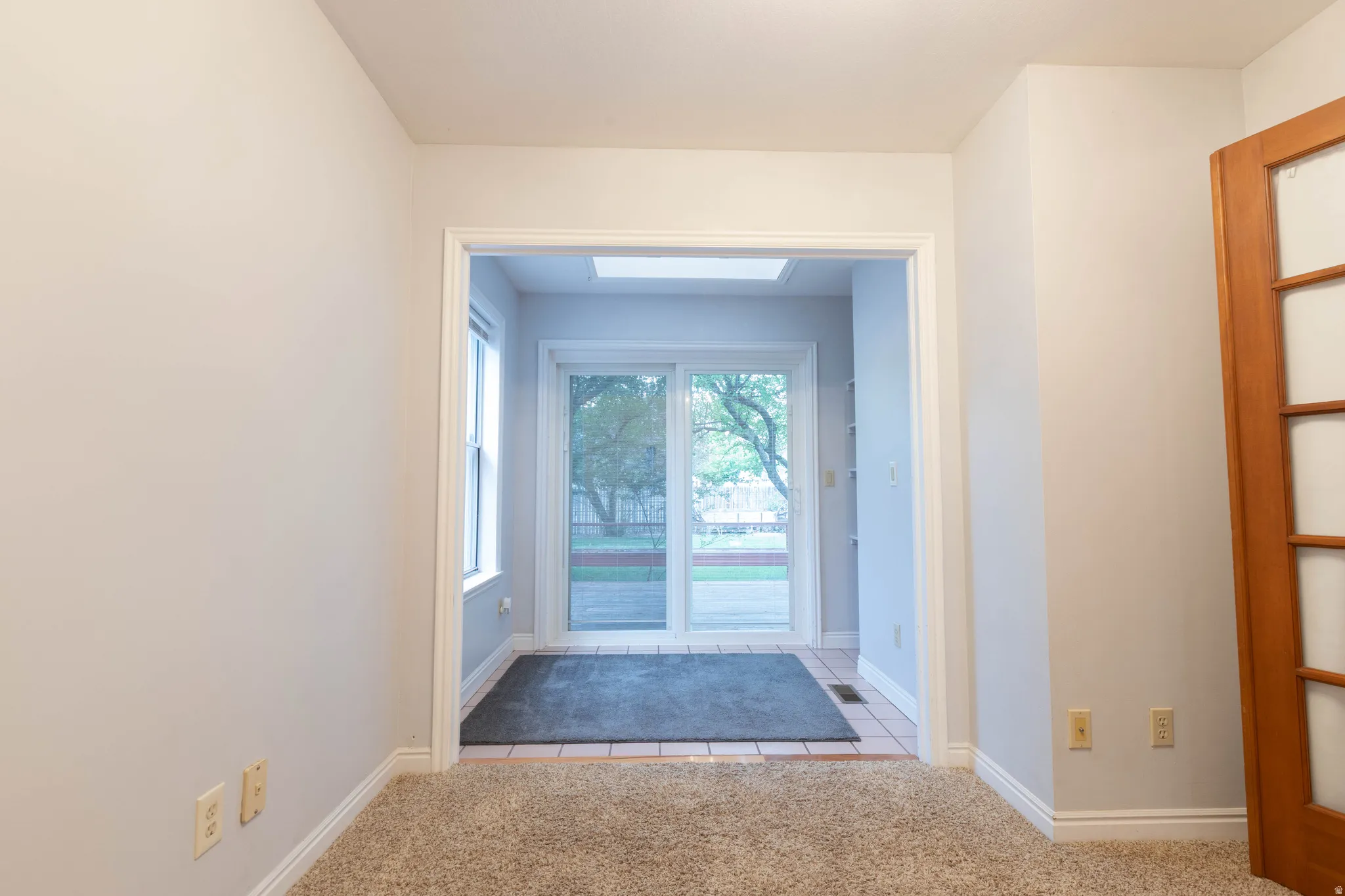 Carpeted room with light neutral walls and white trim