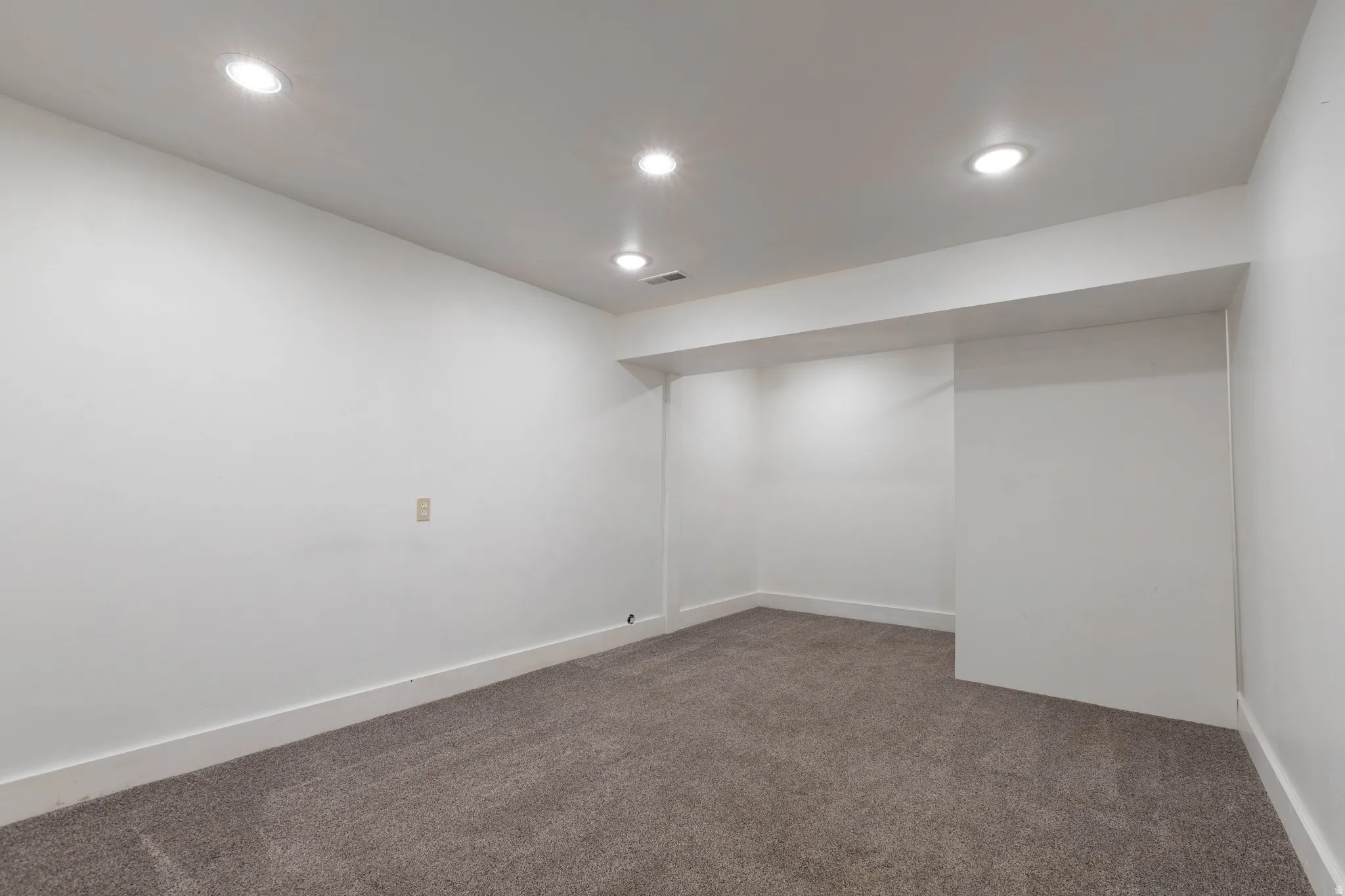 Carpeted room featuring recessed lighting, white walls, and white baseboards