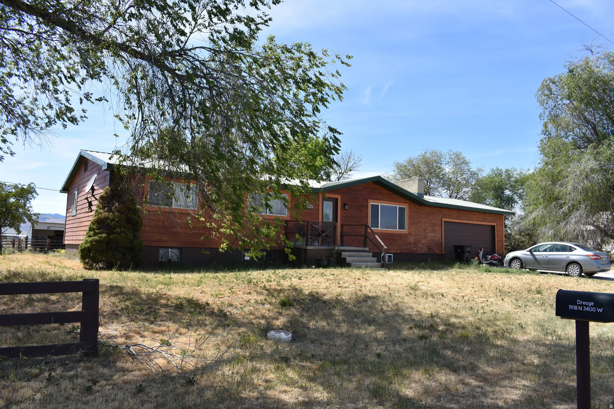 Single-story residence featuring wood-paneled siding, an attached garage, and a covered porch with steps