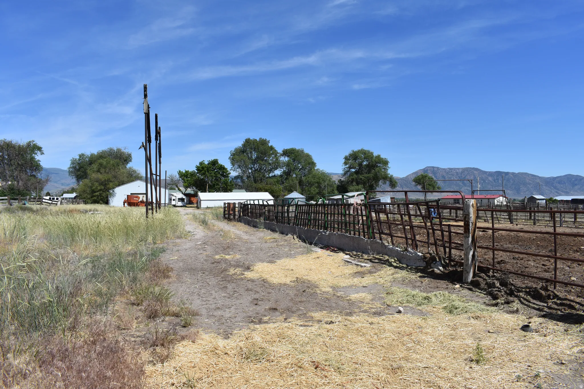 Ranch property featuring multiple outbuildings, metal fencing, and expansive open land