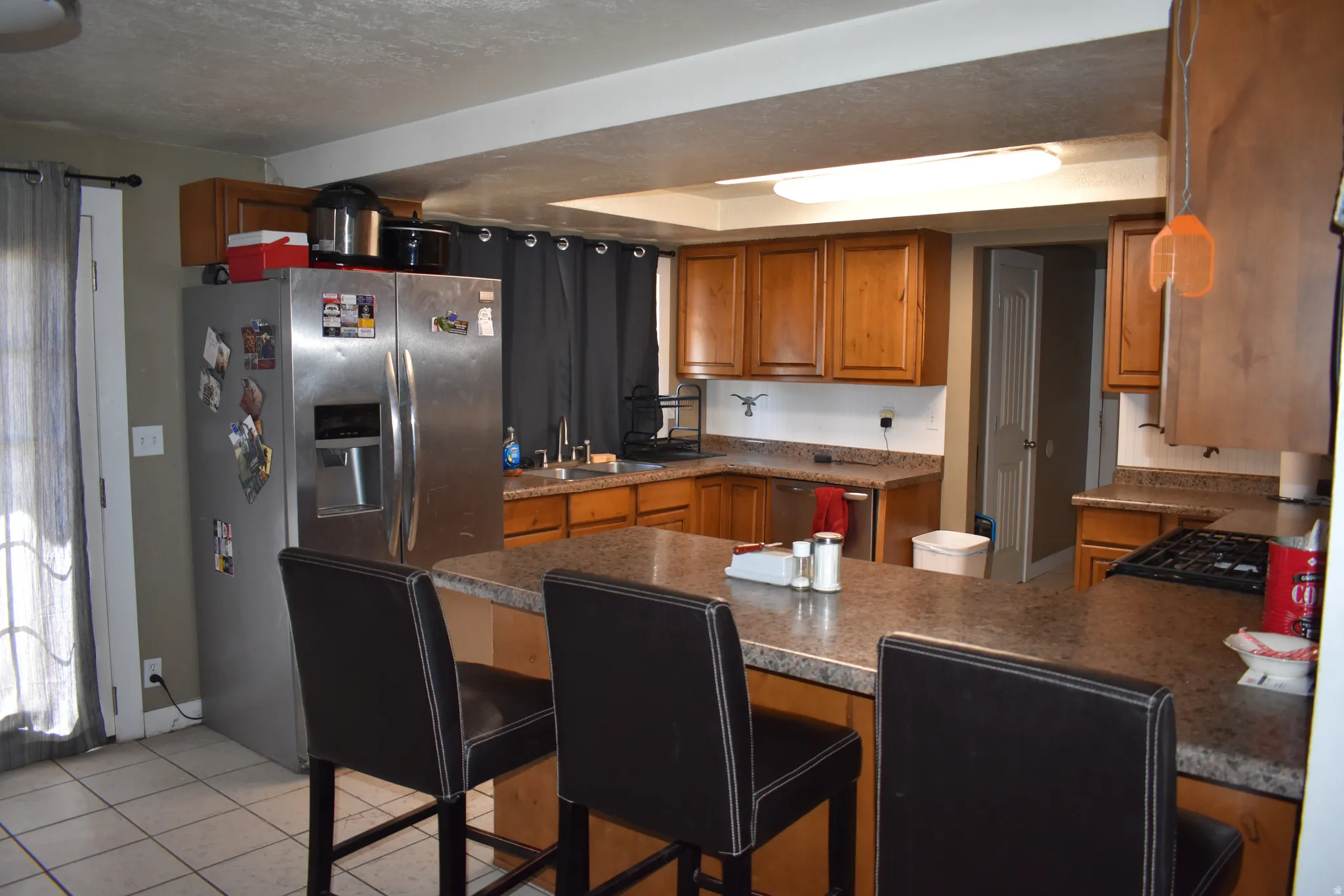 Kitchen featuring wood cabinetry, stone-look countertops, and a built-in gas cooktop
