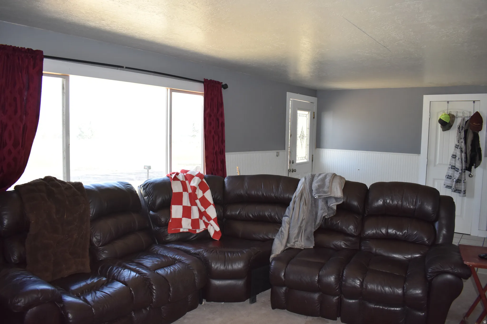 Living area with expansive picture window, gray painted walls, and white beadboard wainscoting