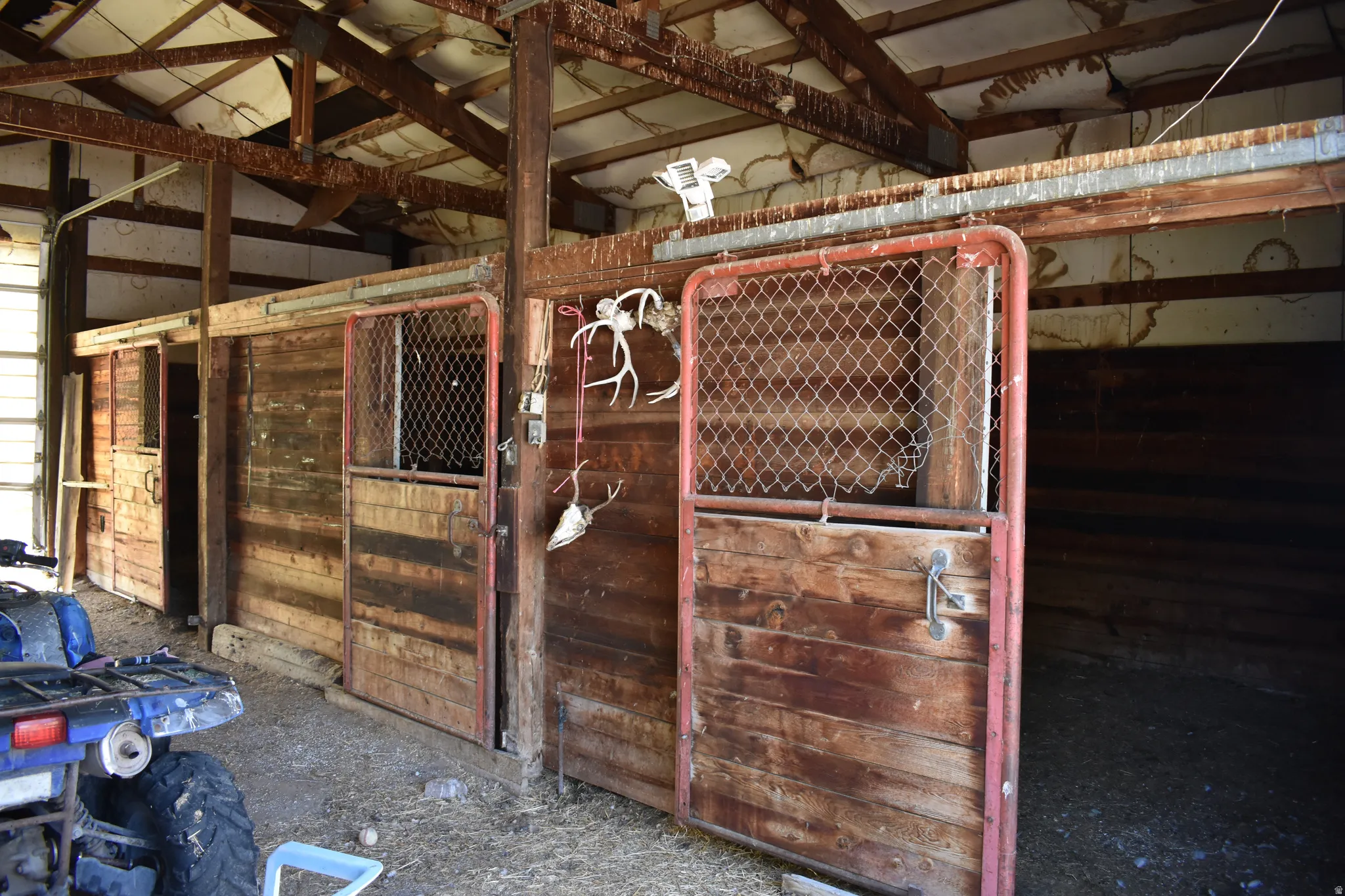 Agricultural structure featuring multiple wood-paneled stalls with metal-framed doors