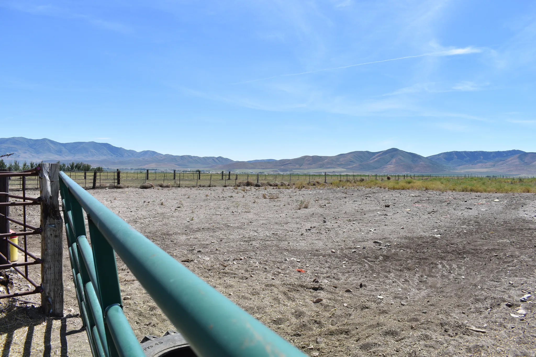 Expansive open land featuring distant mountain ranges and clear skies