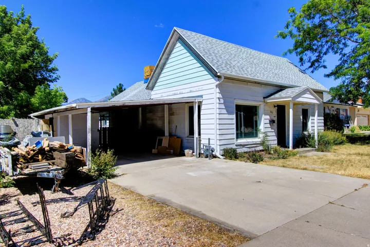 Single-story residence featuring light-colored siding, a covered entry, and a concrete driveway