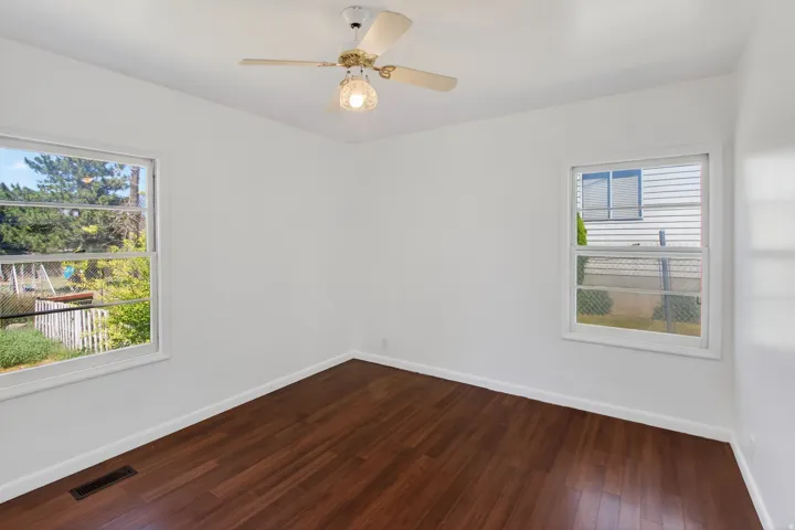 Bright interior space featuring wood-finish flooring, white walls, and white trim