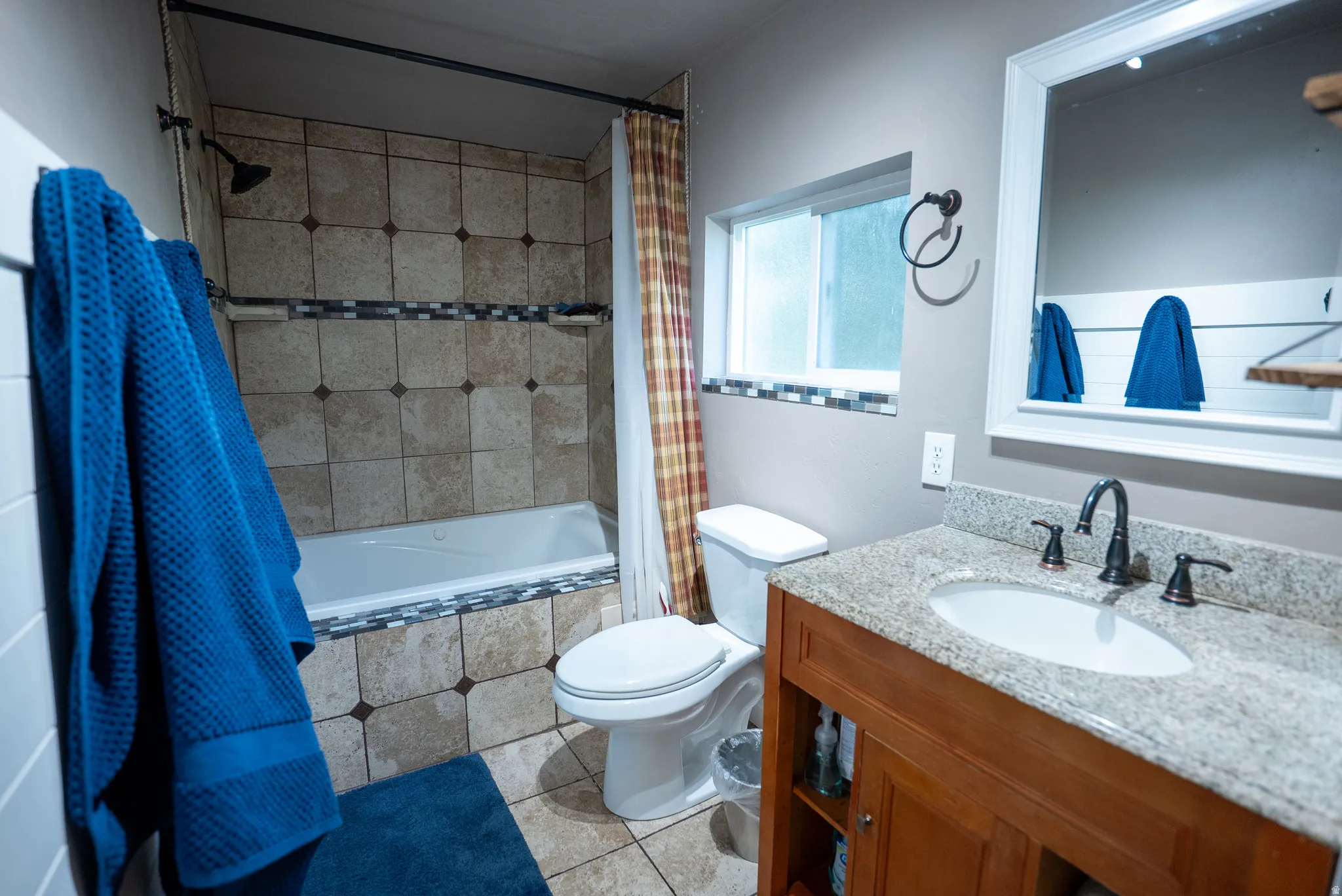 Bathroom featuring a wood-finish vanity with a granite-style countertop, undermount sink, and oil-rubbed bronze fixtures