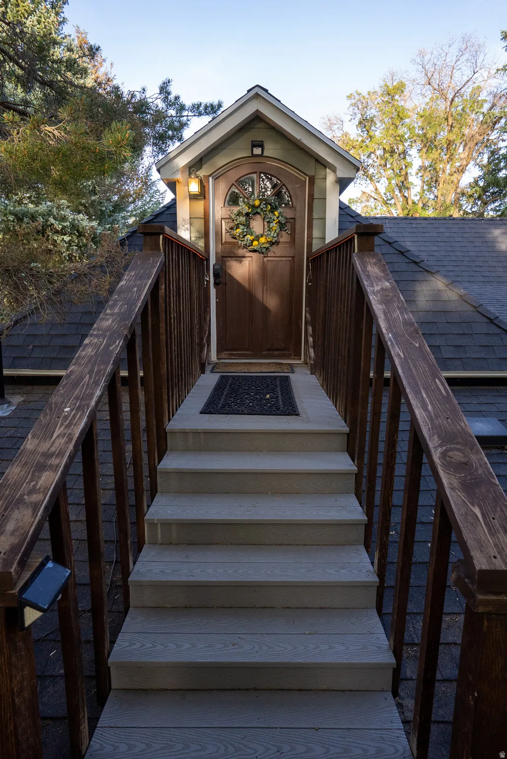 Exterior entrance featuring a wood-finish door with an arched glass panel