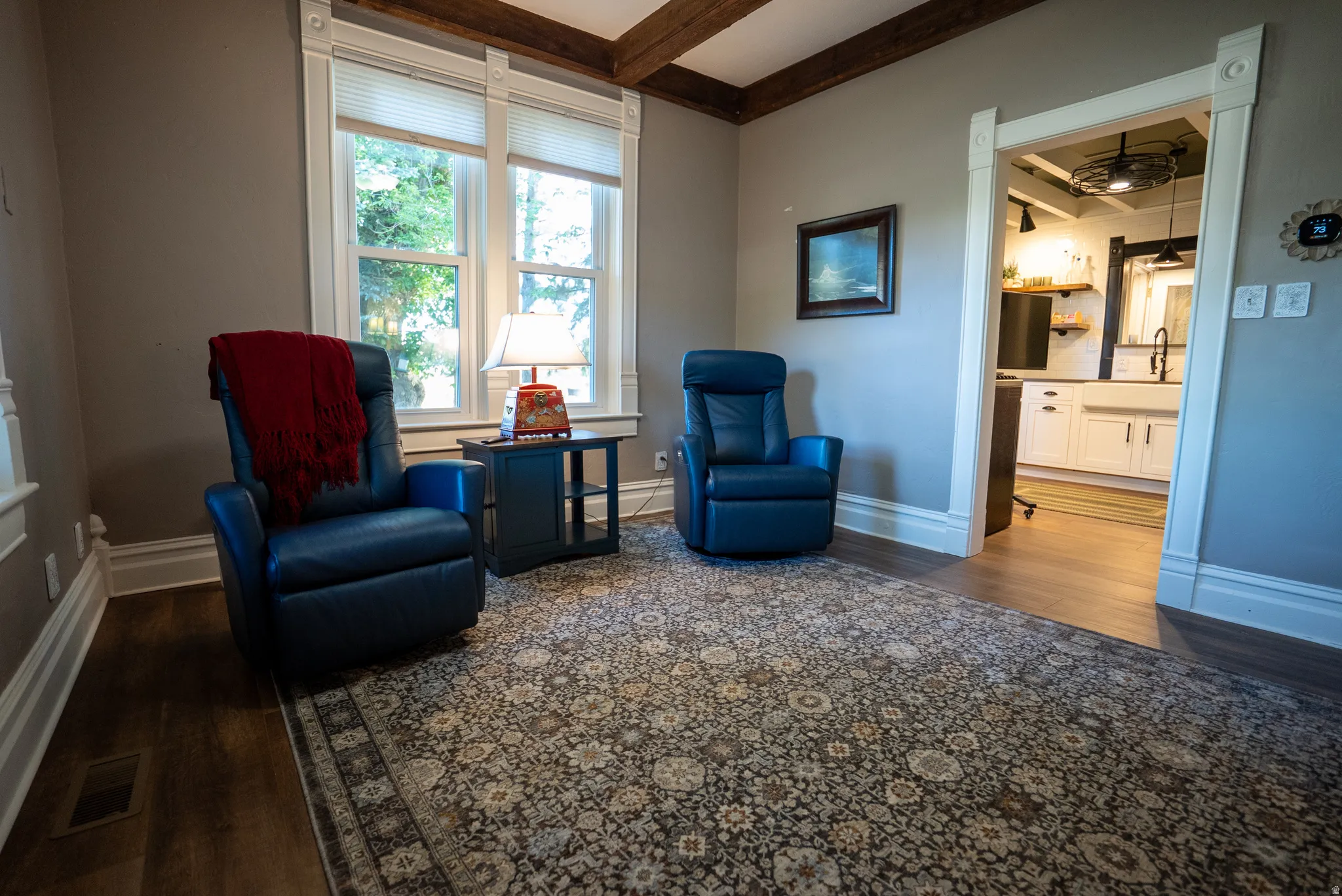Interior space featuring wood-finish flooring, a decorative area rug, and detailed white trim work