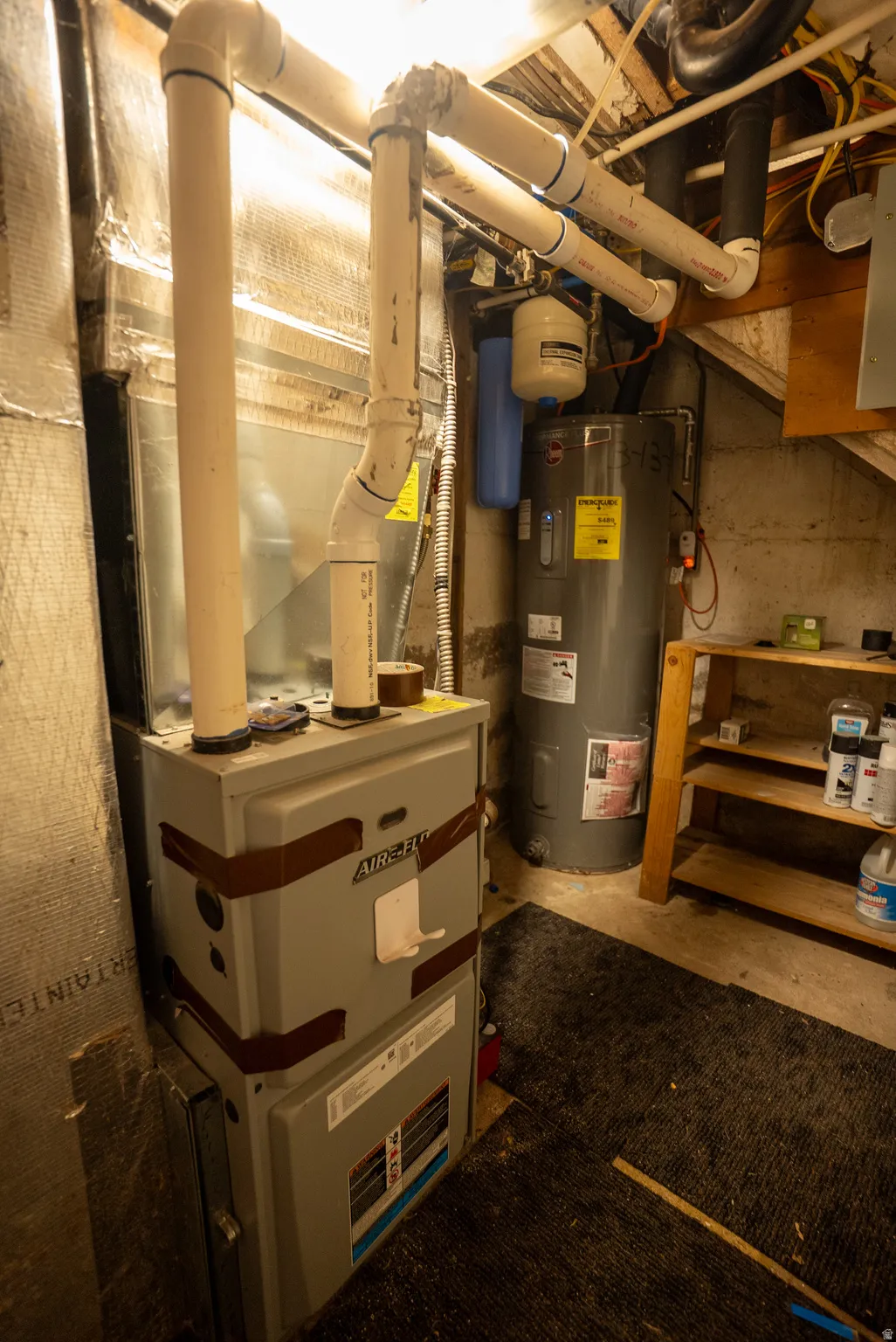 Central air handler with associated ductwork, water heater, water filtration system, and exposed utility piping