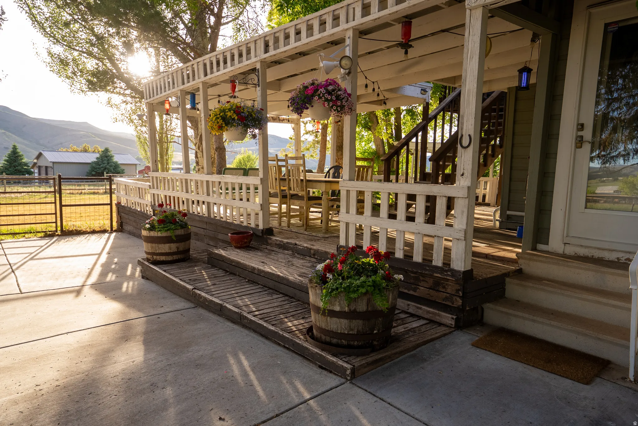 Expansive deck featuring white wood railings, a pergola roof, and direct access to concrete patio space