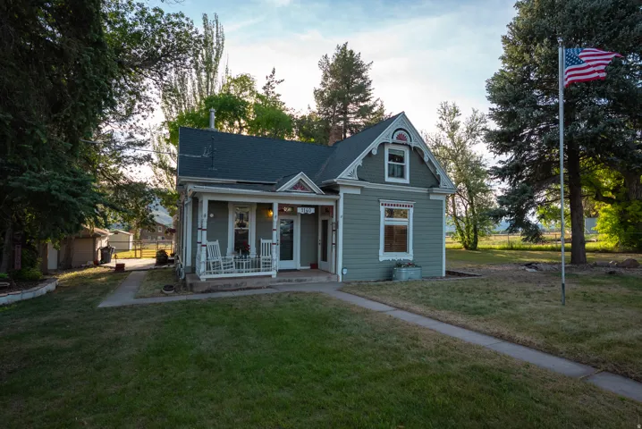 Traditional two-story exterior with a covered porch, gabled roofline, and dormer window