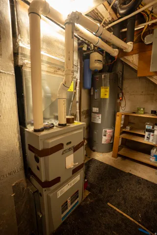 Central air handler with associated ductwork, water heater, water filtration system, and exposed utility piping