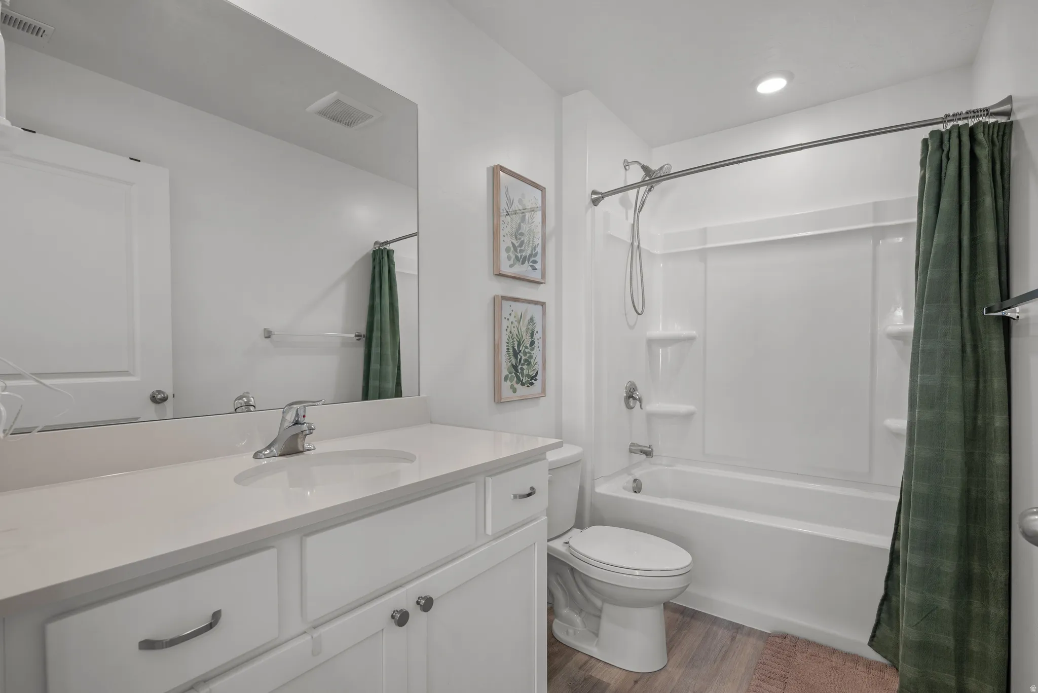 Bathroom featuring a white vanity with an integrated sink, polished chrome faucet, and expansive mirror