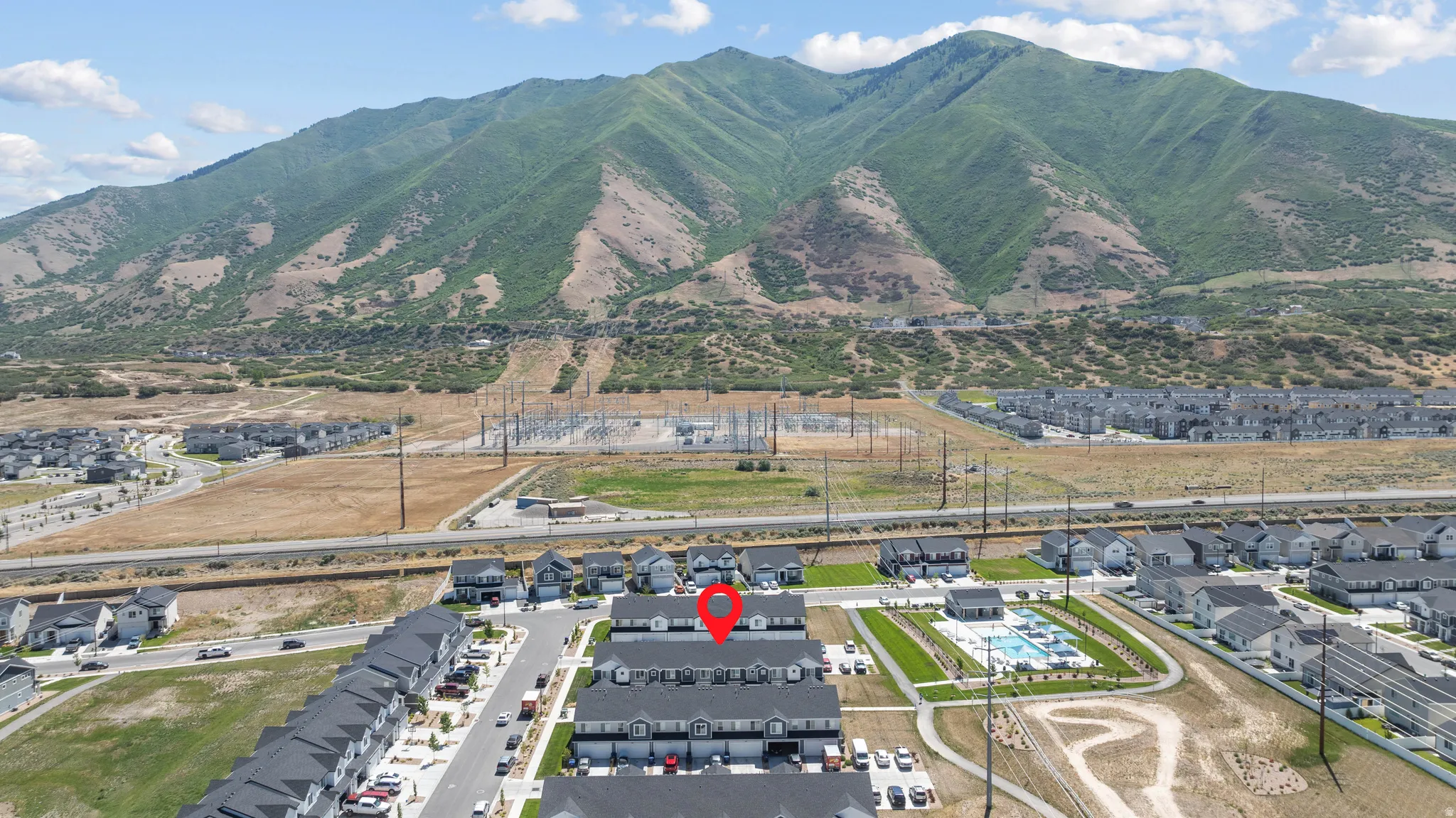 Aerial view showcasing a community of townhomes with mountain backdrop