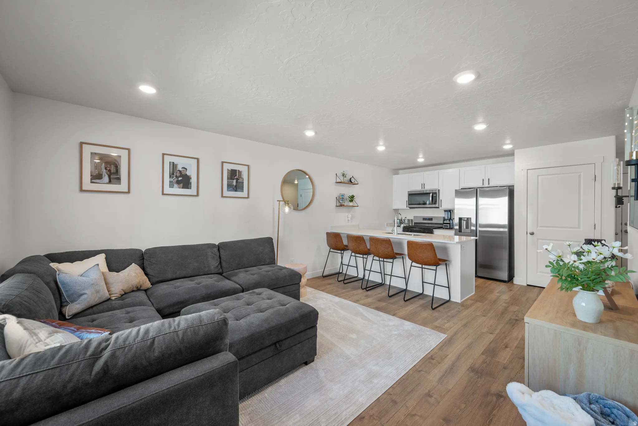 Open-concept living space featuring wood-finish flooring and recessed lighting