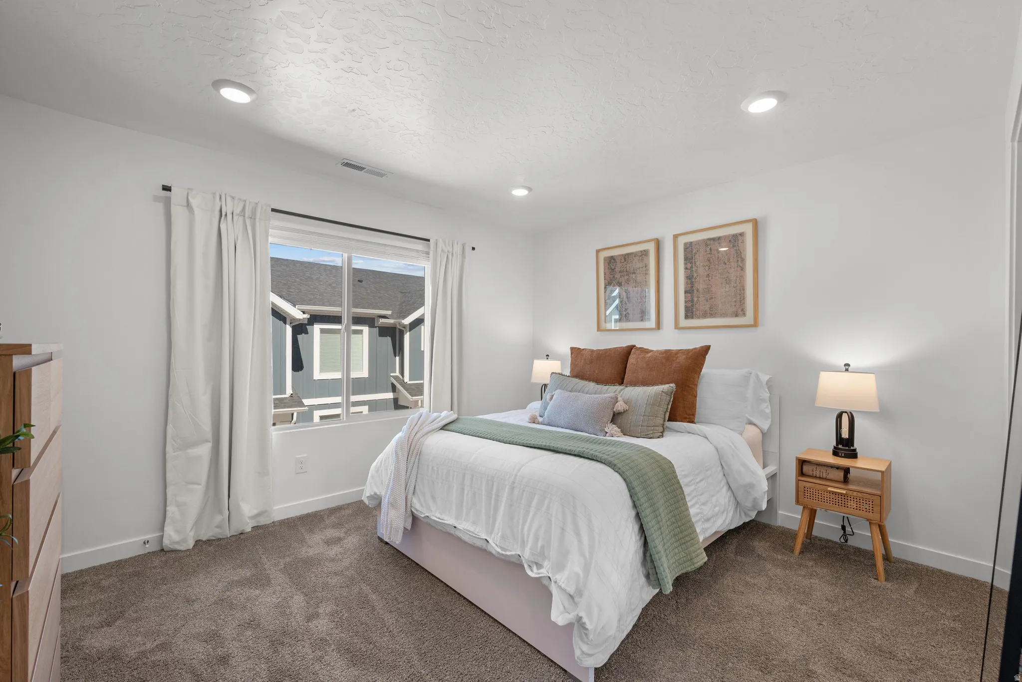 Bedroom featuring a large window with white curtains, recessed lighting, neutral carpet flooring, and white walls