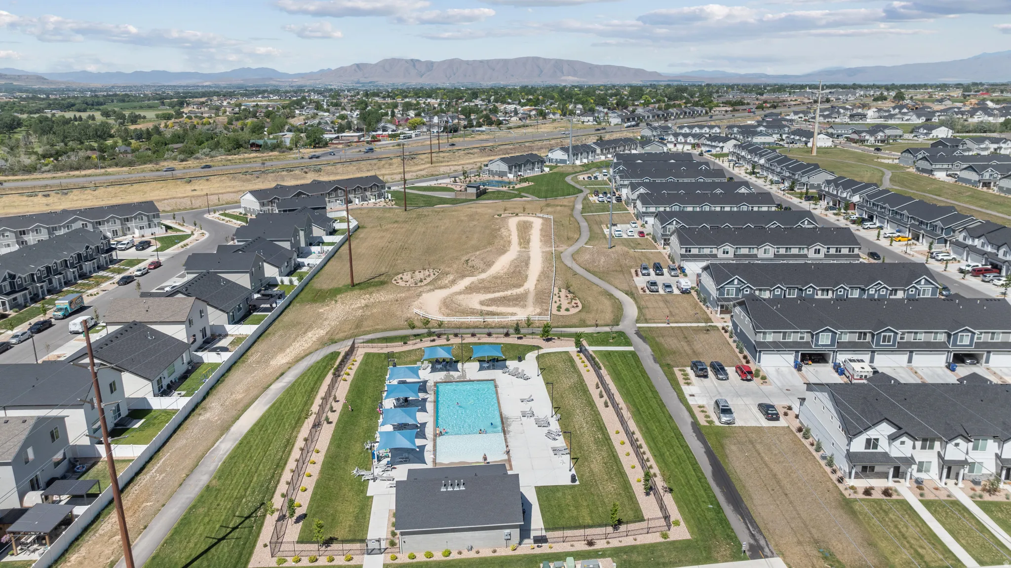 Expansive community featuring an outdoor swimming pool, recreation building, and multiple residential structures