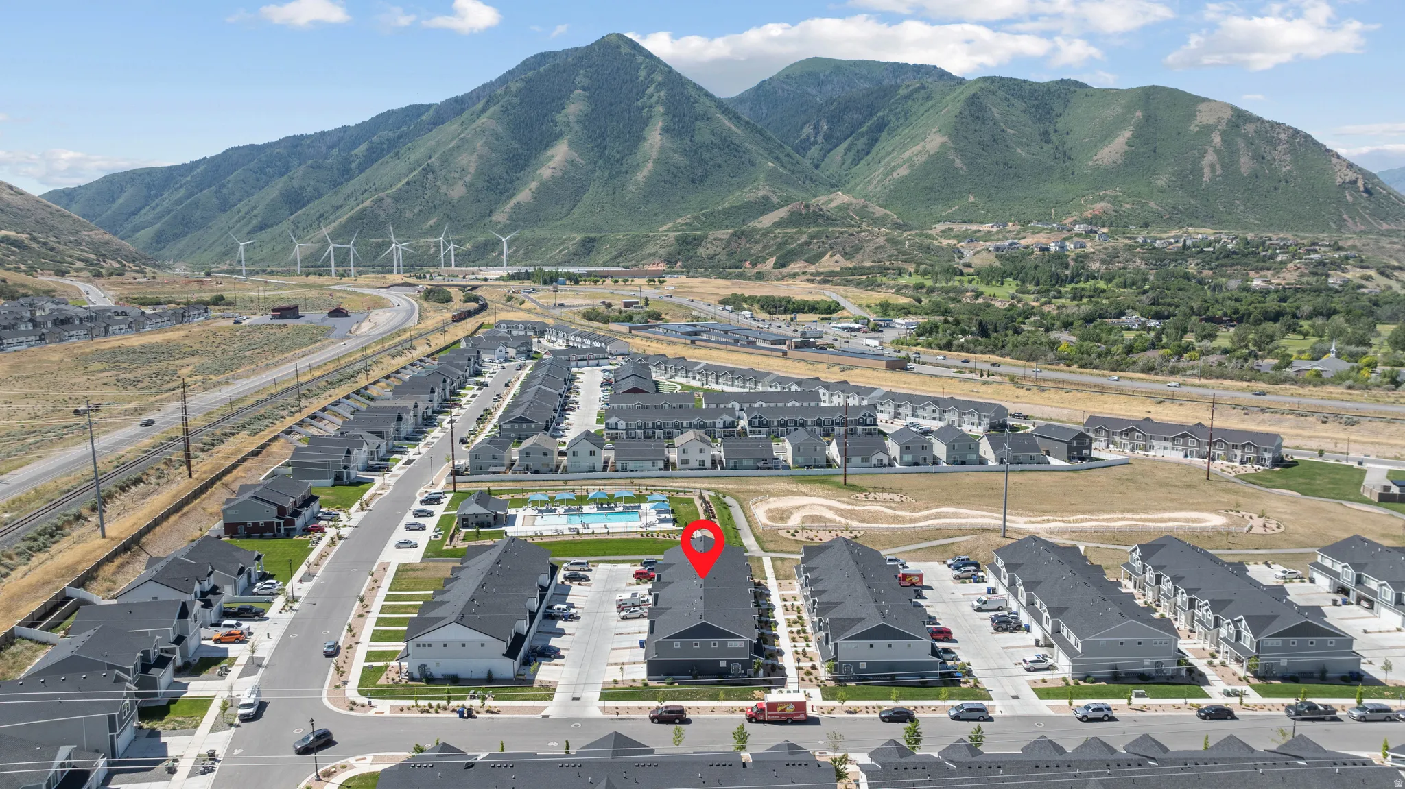 Modern residential development featuring multi-story townhomes with dark roofs