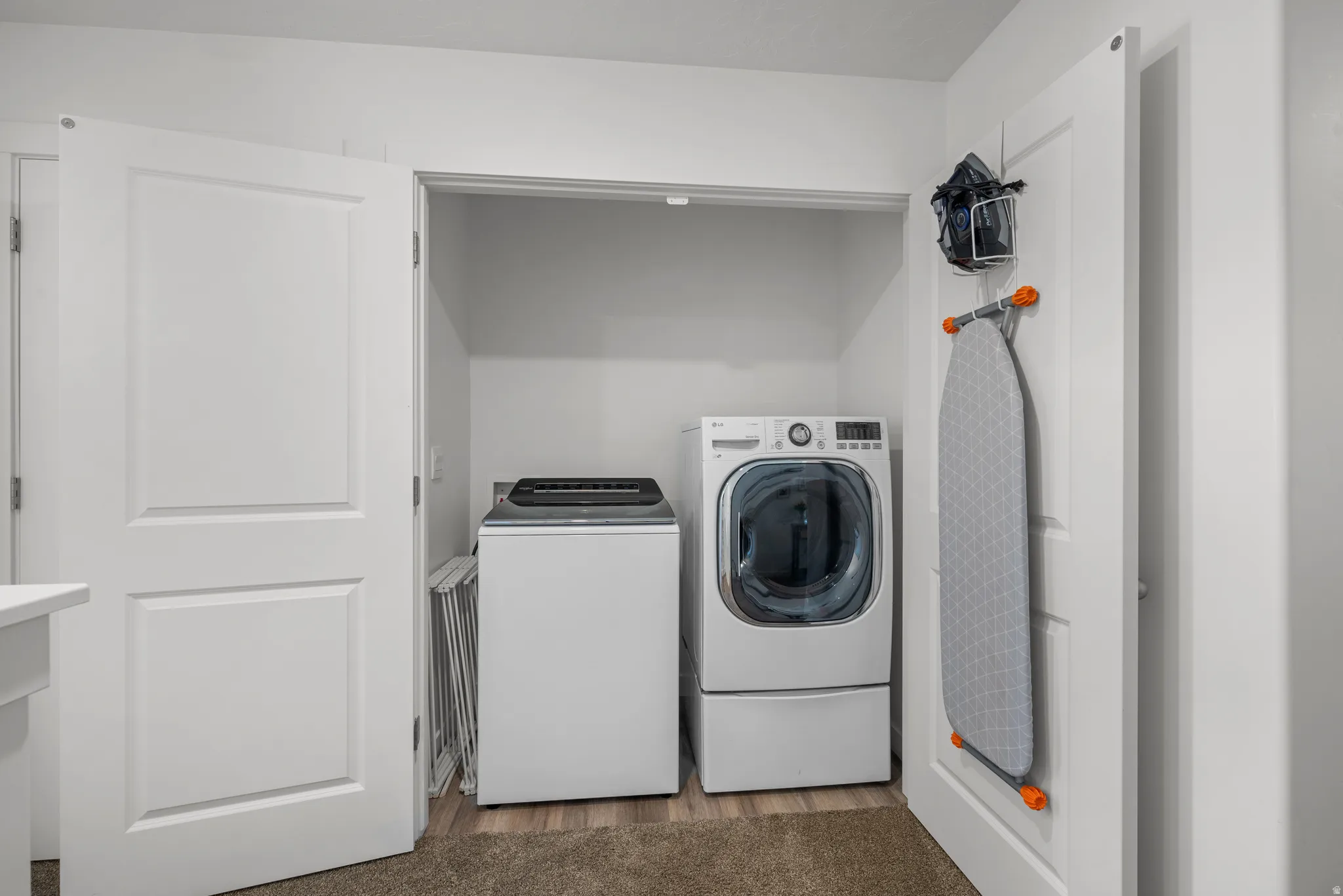 White laundry closet featuring a top-load washing machine and a front-load dryer