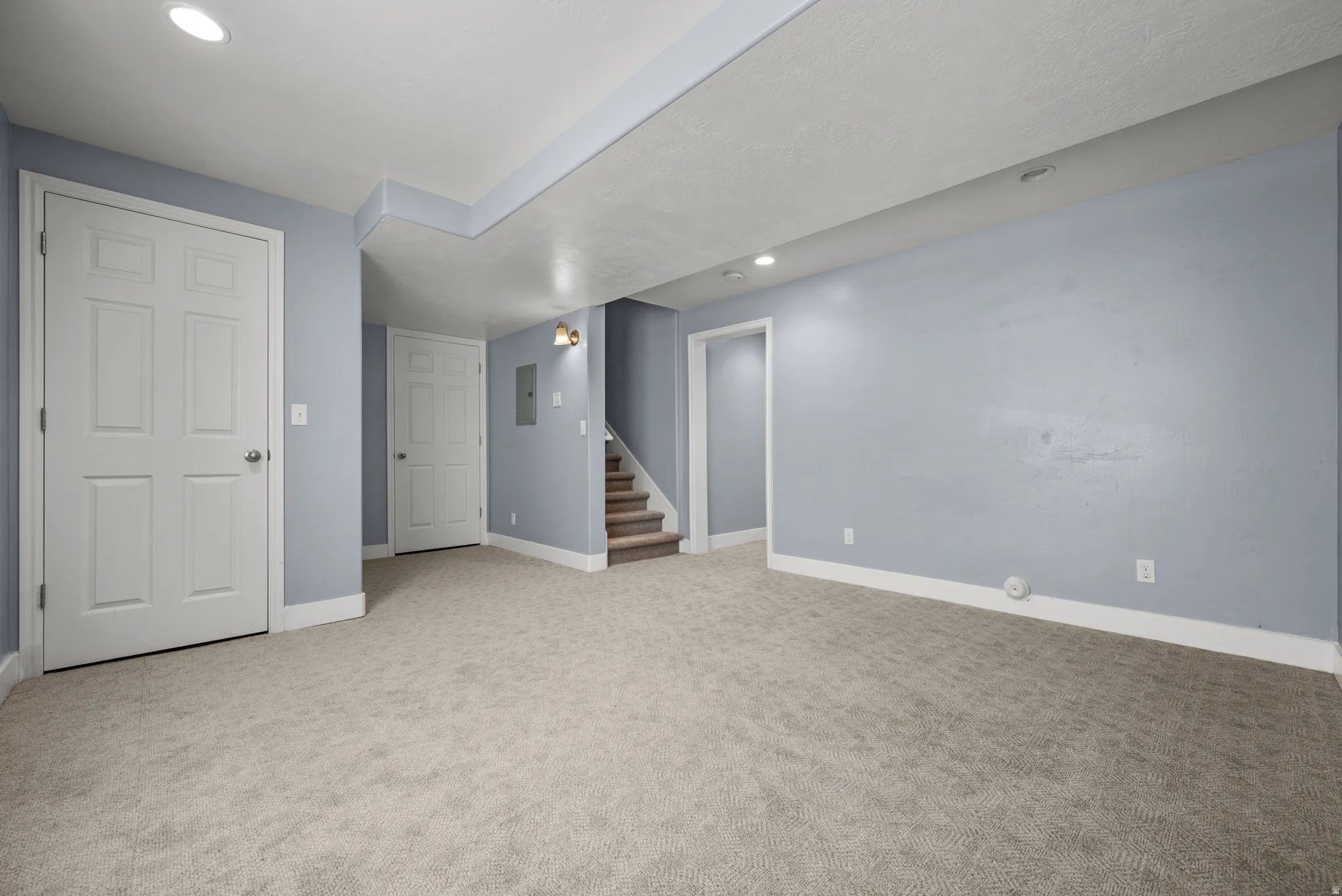 Spacious carpeted room featuring recessed lighting and light blue walls