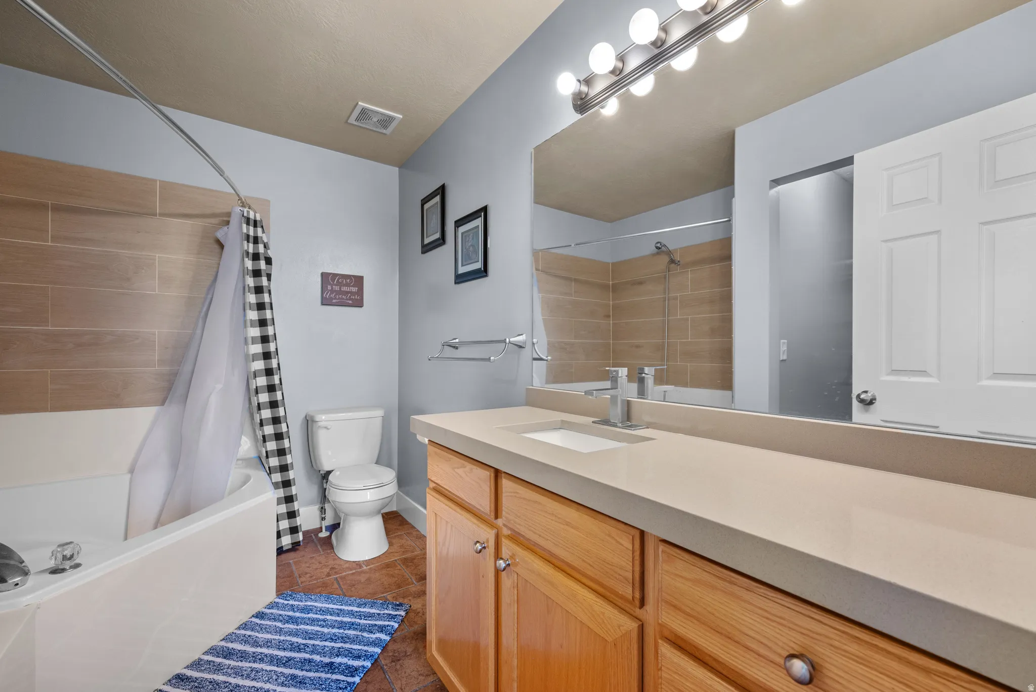 Bathroom featuring an expansive vanity with an integrated sink, brushed nickel faucet, and a large wall mirror