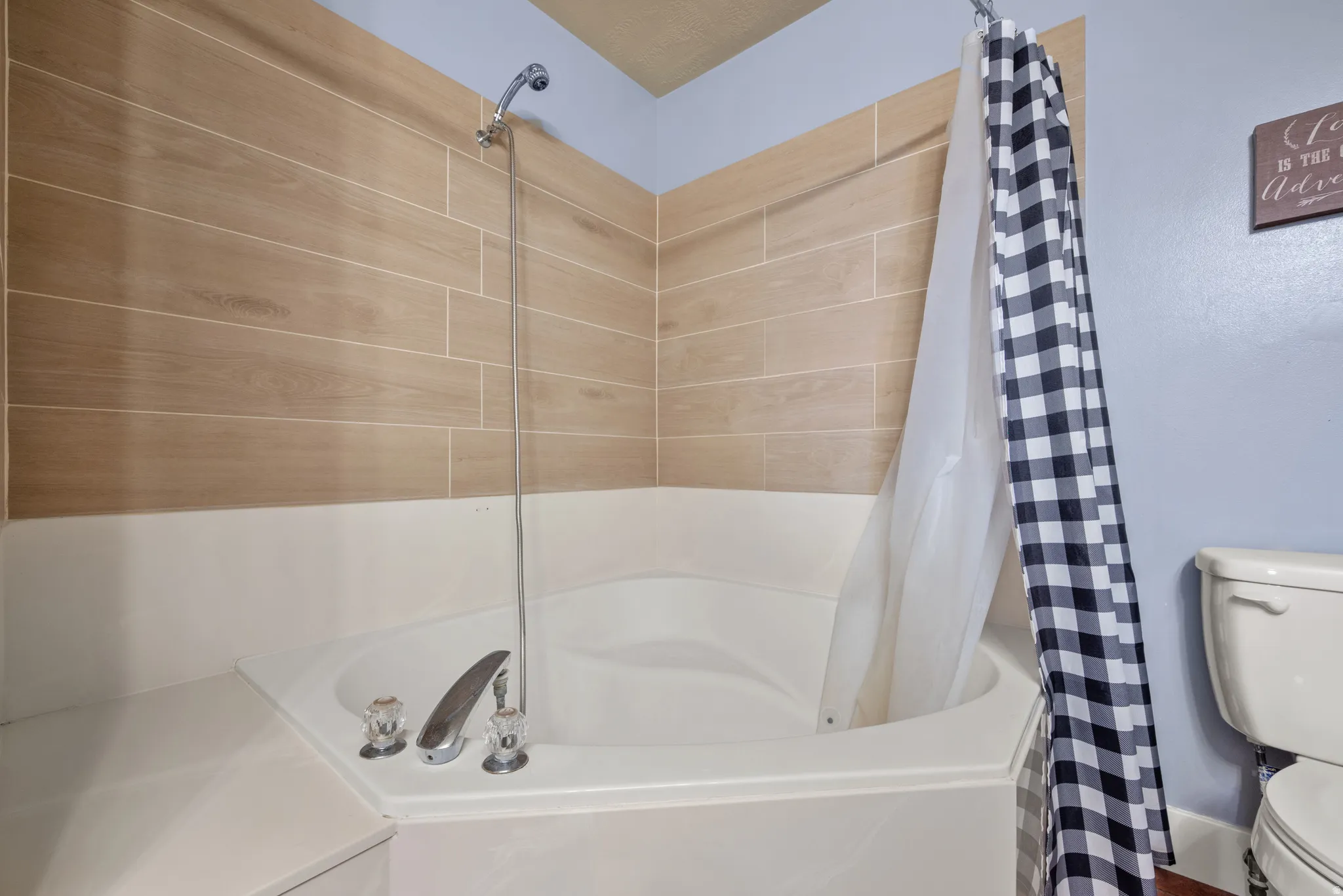 Corner soaking tub with a curved basin and a chrome faucet featuring clear acrylic handles