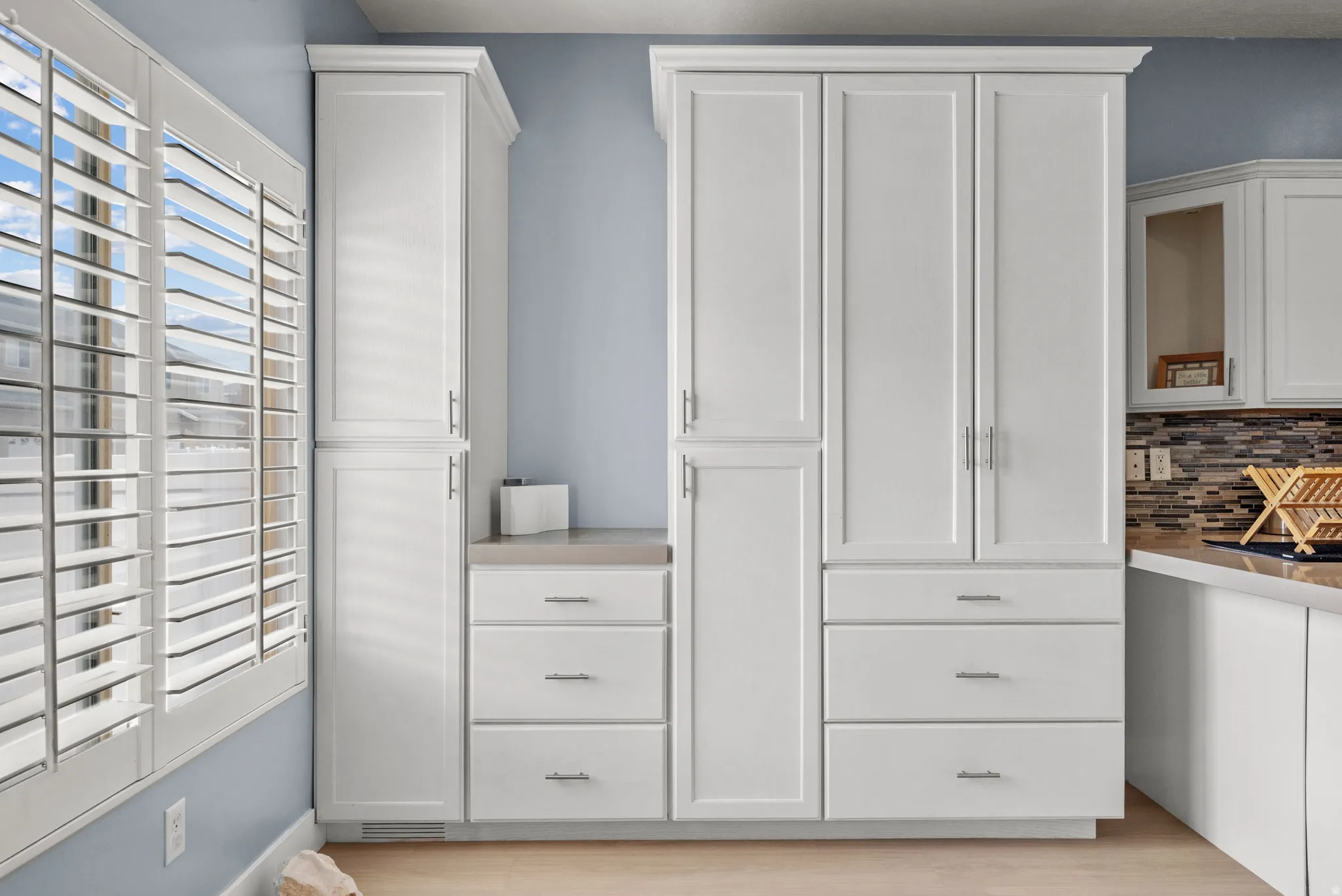 White custom cabinetry with chrome hardware and crown molding