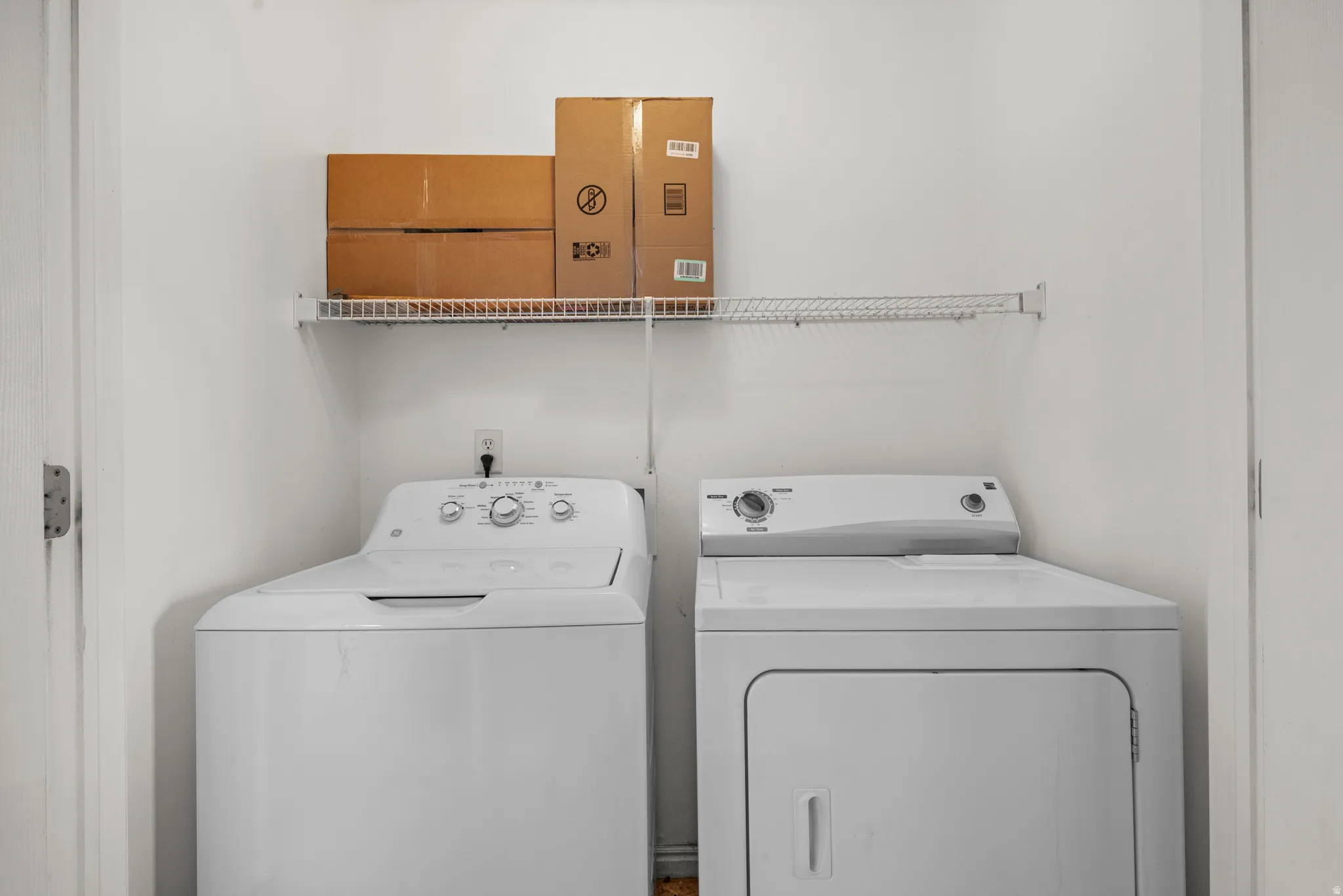 Dedicated laundry area featuring a white top-load washer and a white front-load dryer