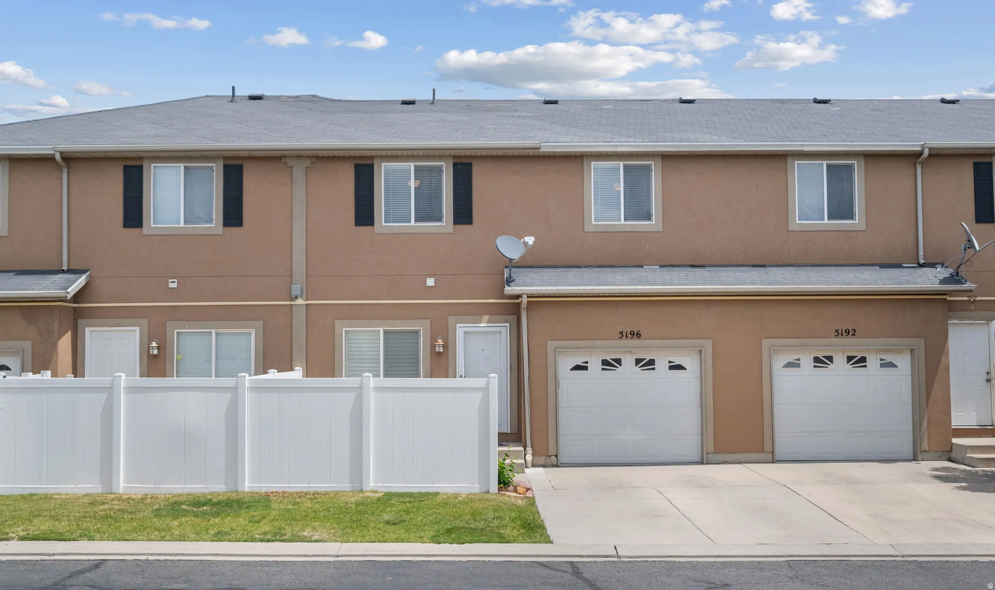 Multi-level townhome-style residences featuring stucco exteriors and shingle roofing