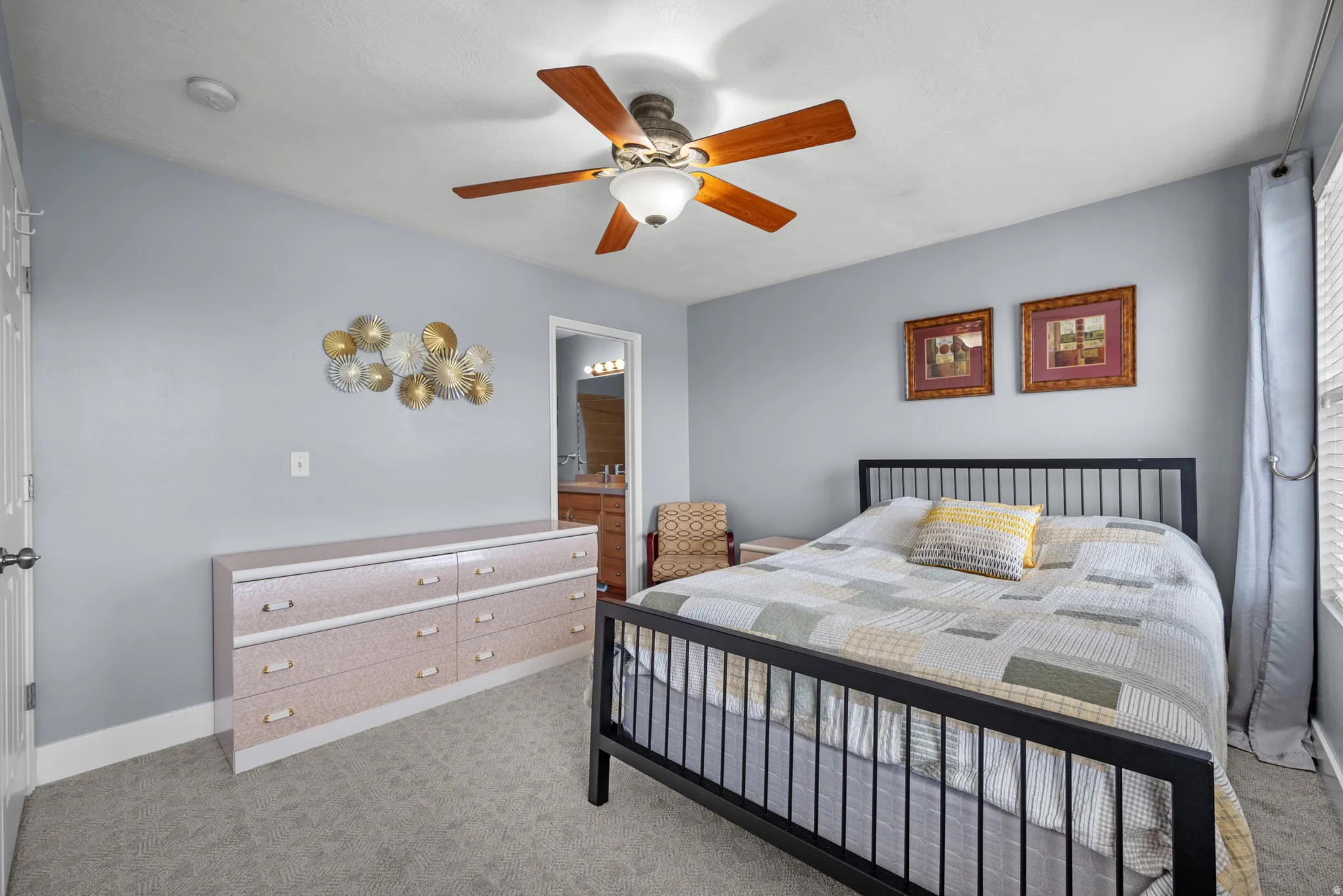Spacious room featuring carpet flooring, light gray wall paint, and a ceiling fan with integrated lighting