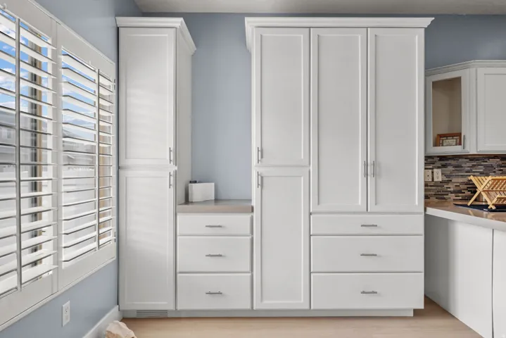 White custom cabinetry with chrome hardware and crown molding