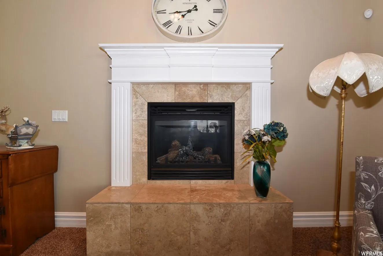 Tiled fireplace with a gas insert, white mantel, and hearth