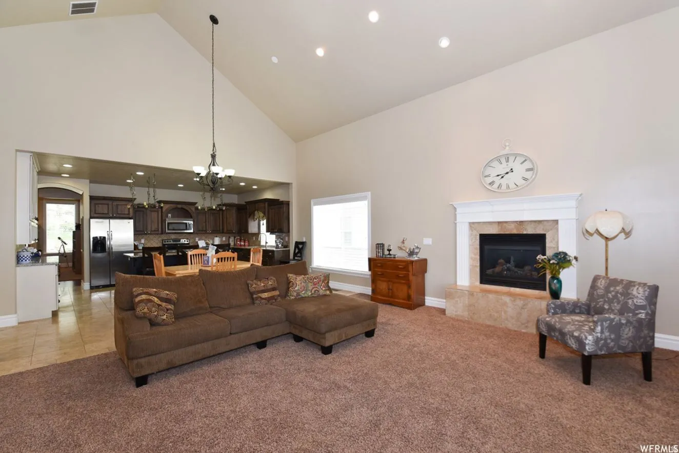 Spacious living area featuring a vaulted ceiling and recessed lighting