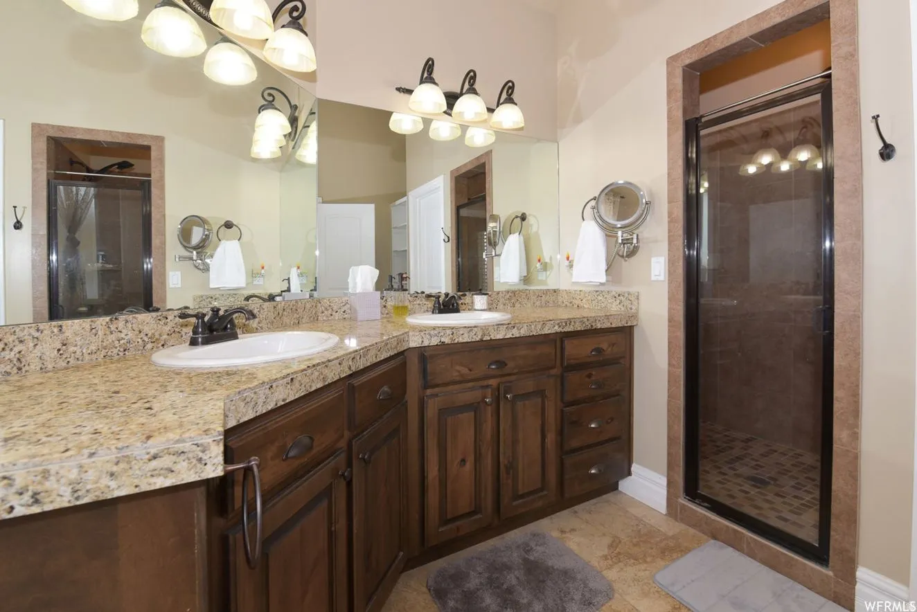 Dual undermount sinks set into a granite countertop with rich wood cabinetry