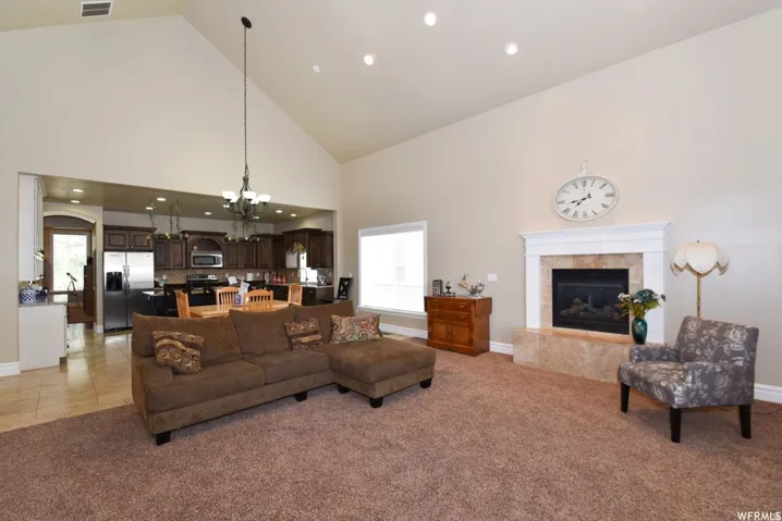 Spacious living area featuring a vaulted ceiling and recessed lighting